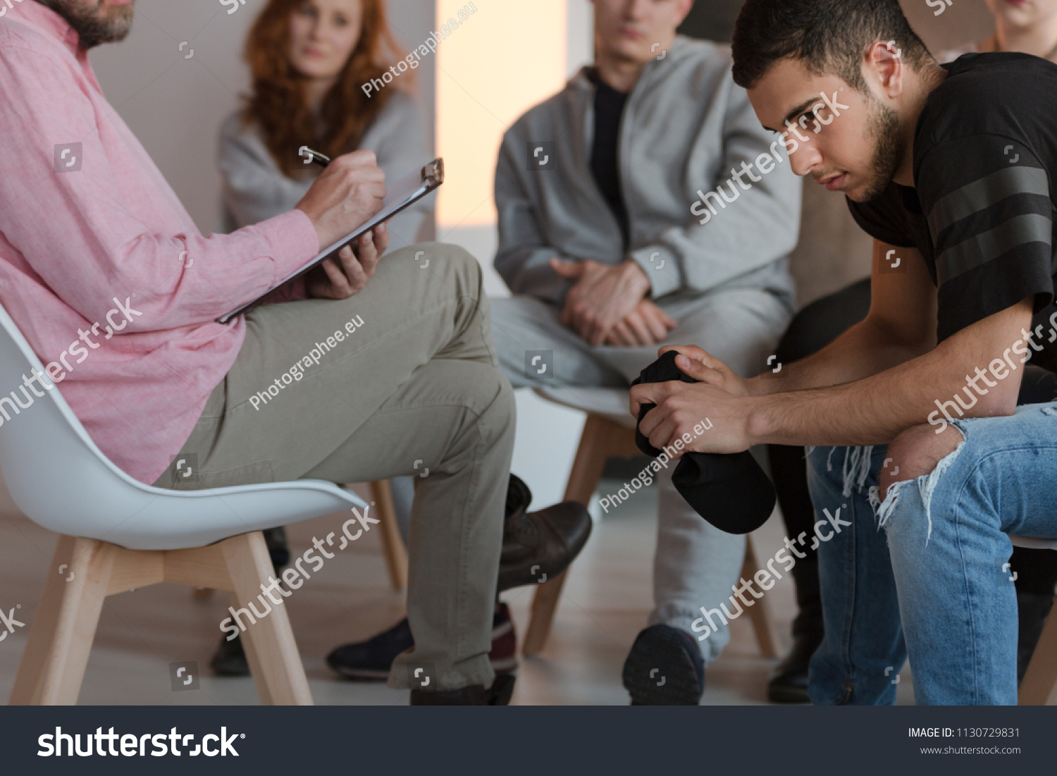 Arrogant teenager sitting at a meeting of support group while his therapist is talking #1130729831