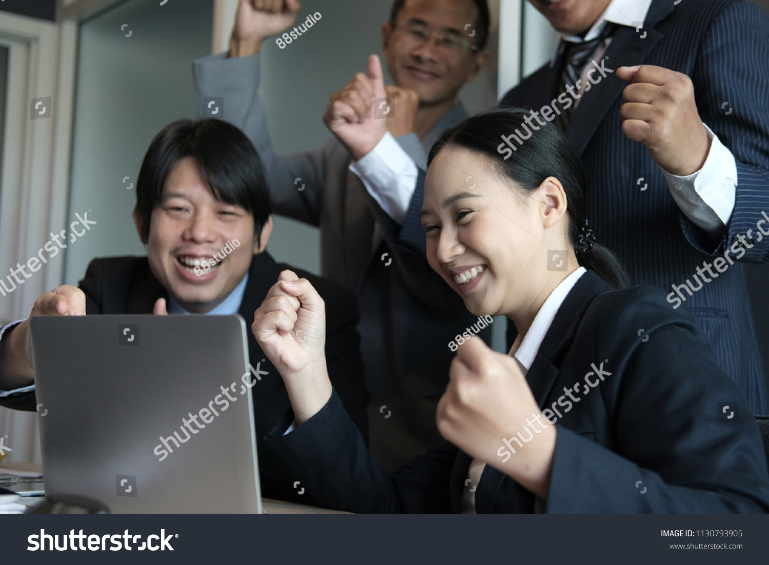 business team raise hands with happiness for successful project. cheerful asian businessman & businesswoman showing gladness for achievement #1130793905