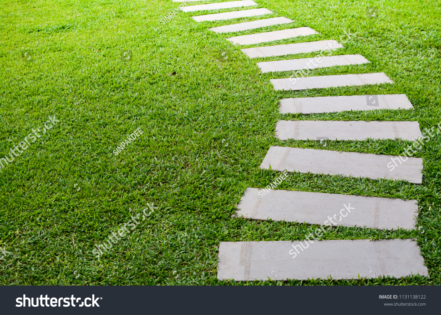 Pathway in the garden outdoor, forward stepping stones or pebbled in the grass lawn. Using for the roadway to success, achievement, leadership, milestone, vision, and mission concept. #1131138122
