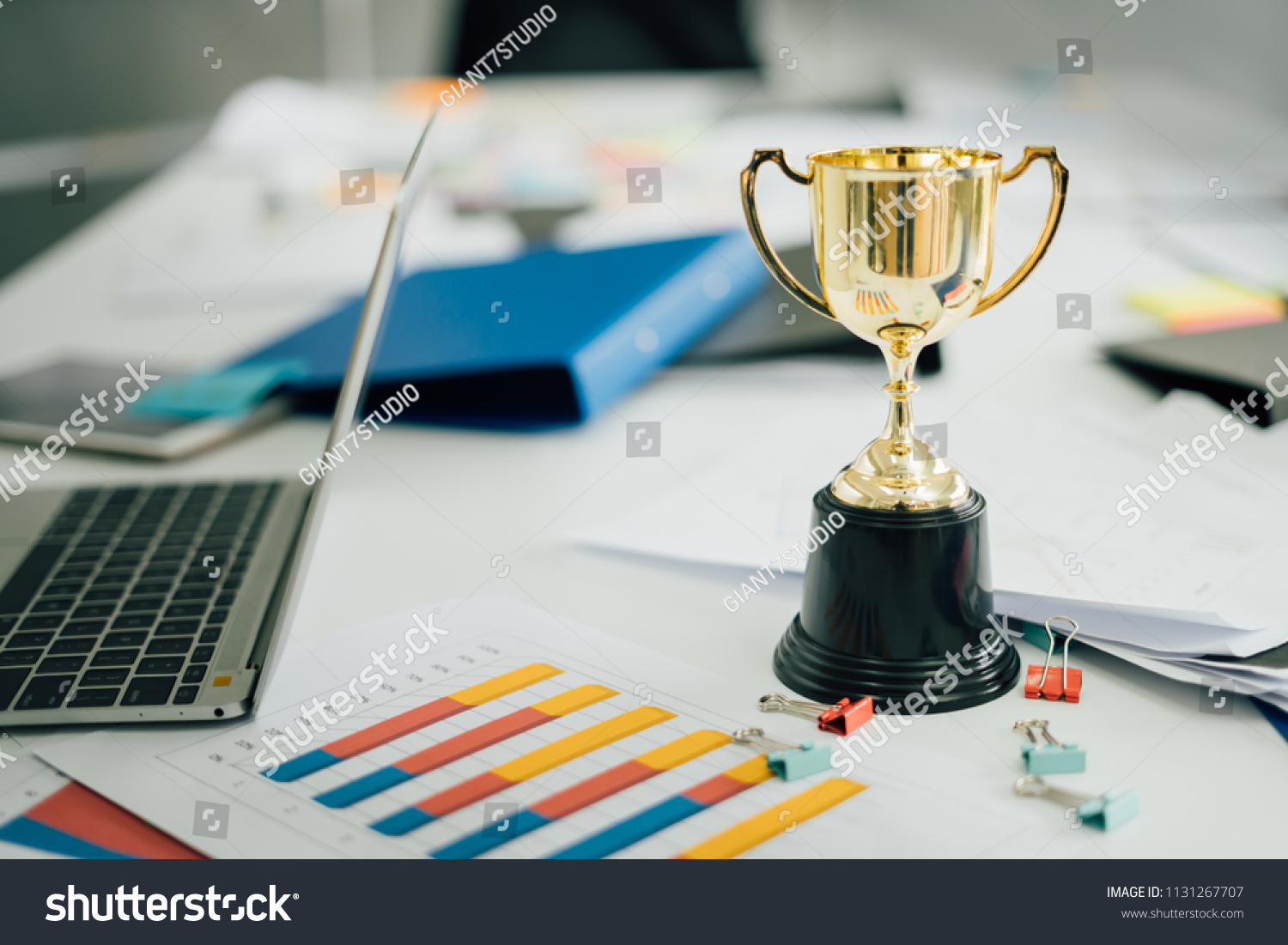 champion golden trophy on table.Award trophy on working table with document and contract #1131267707