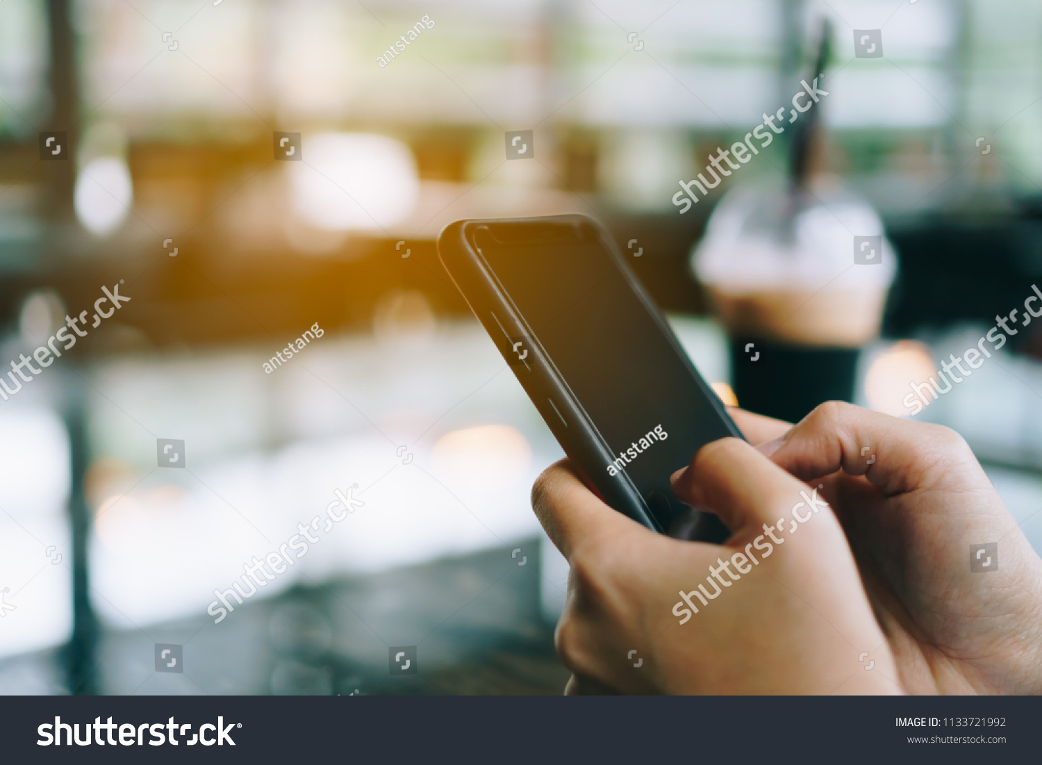 Woman hand using smartphone with cafe shop colorful highlight shade to object beautiful background. Business, financial, trade stock maket and social network concept. #1133721992