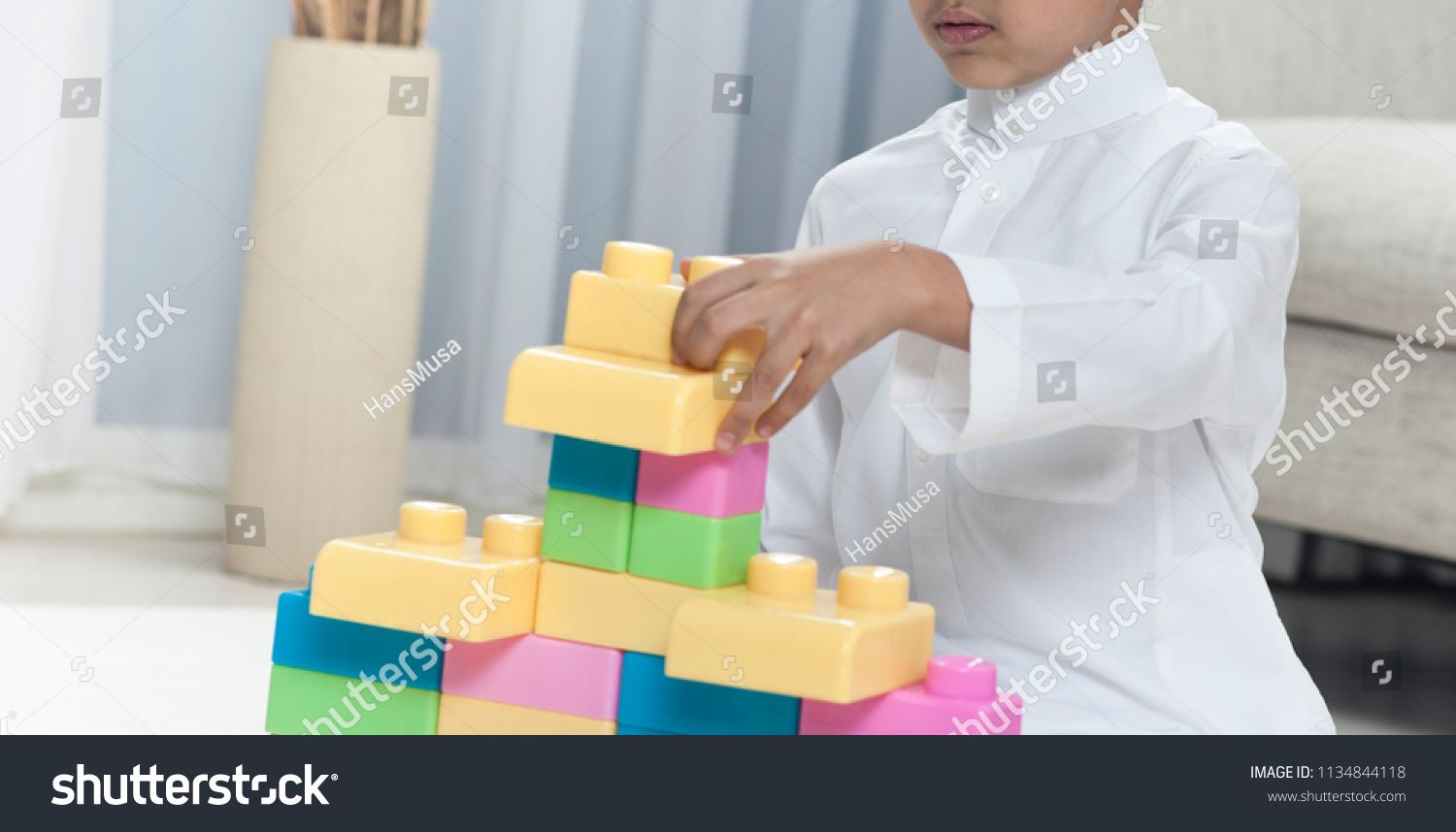 Boy building with colorful toy bricks at home #1134844118