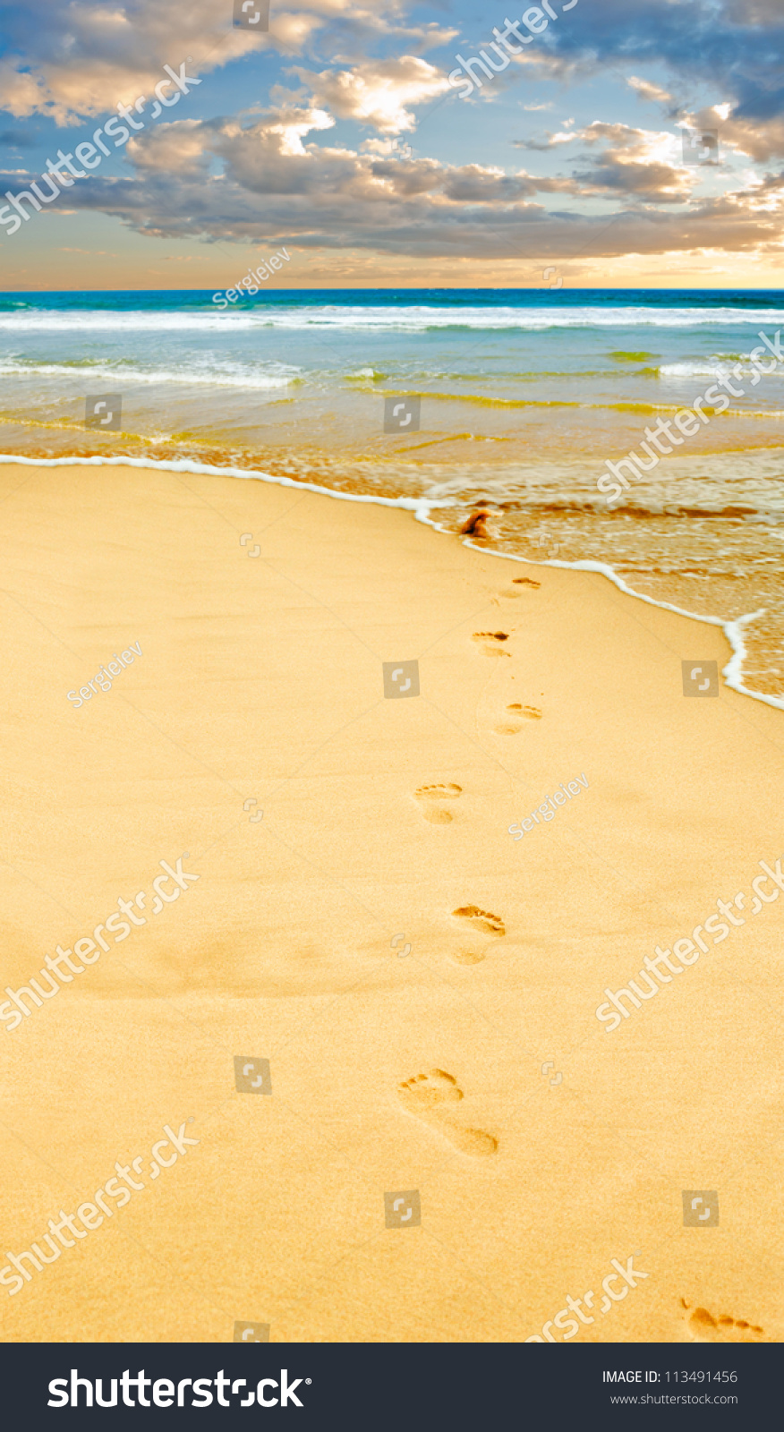 Footprints in the yellow sand, sea in distance. #113491456