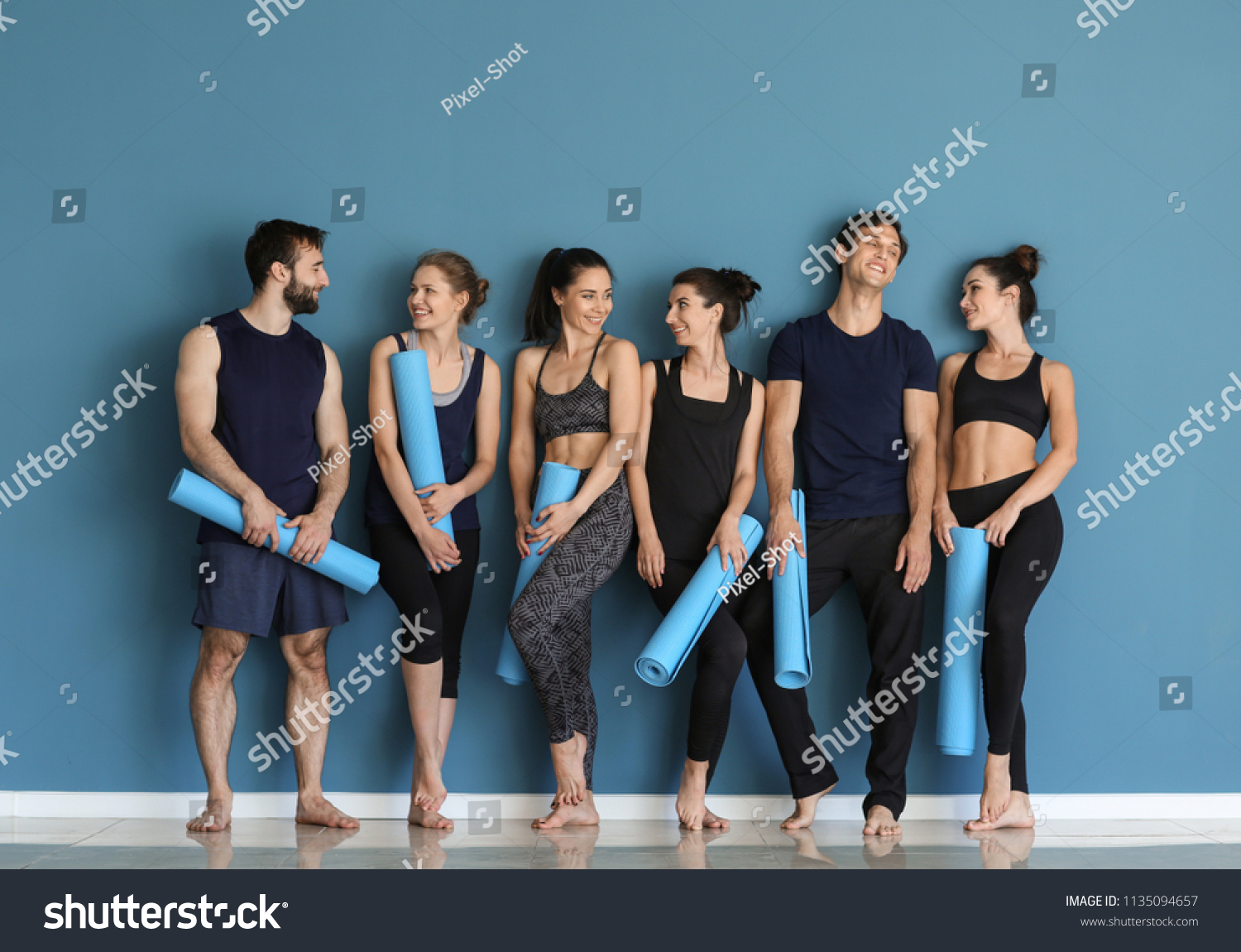 Group of people with yoga mats near color wall #1135094657