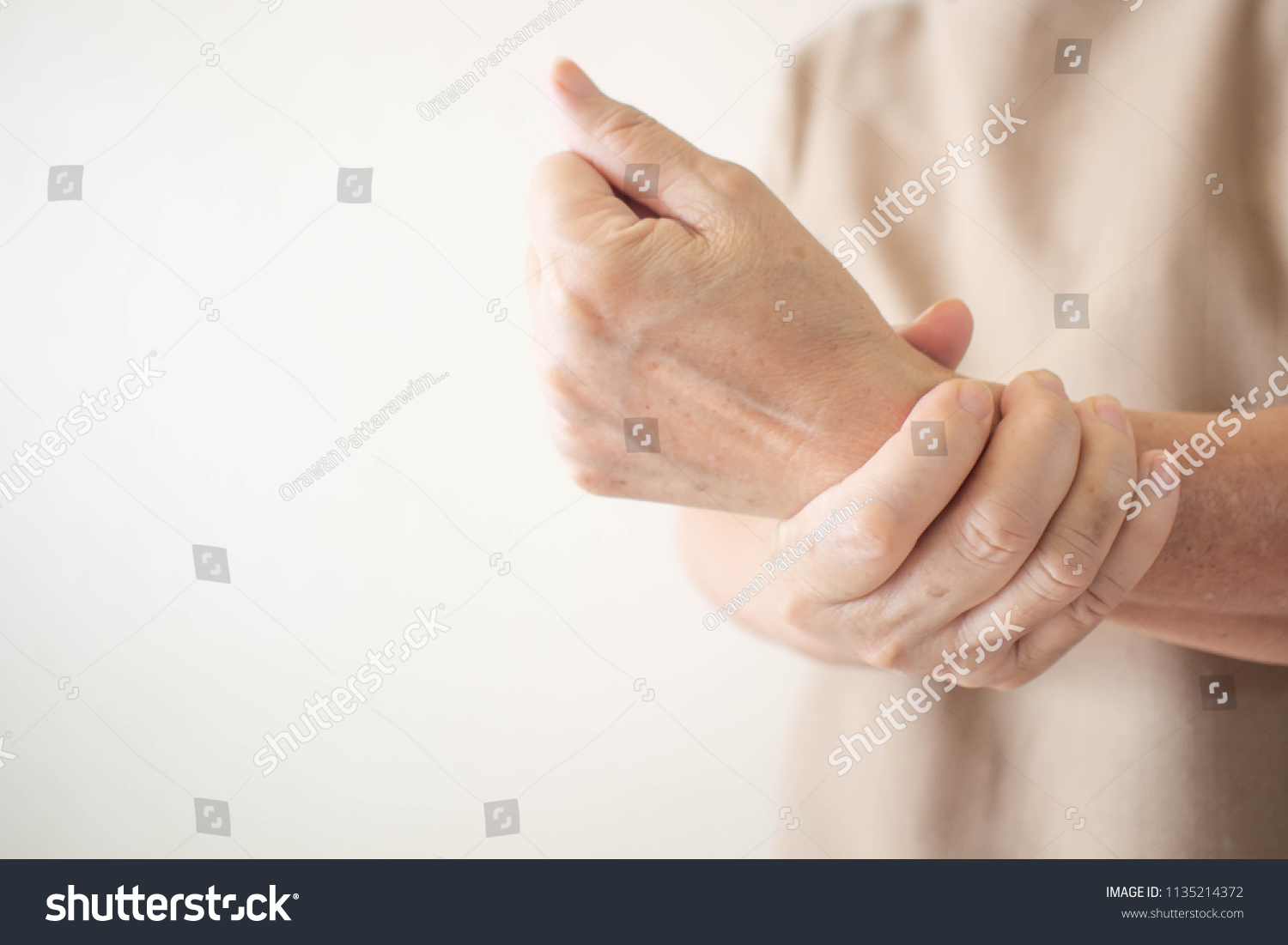 Elderly woman suffering from pain, weakness and tingling in wrist. Causes of hurt include osteoarthritis, rheumatoid arthritis, gout or wrist sprain. Health care concept. Copy space. #1135214372
