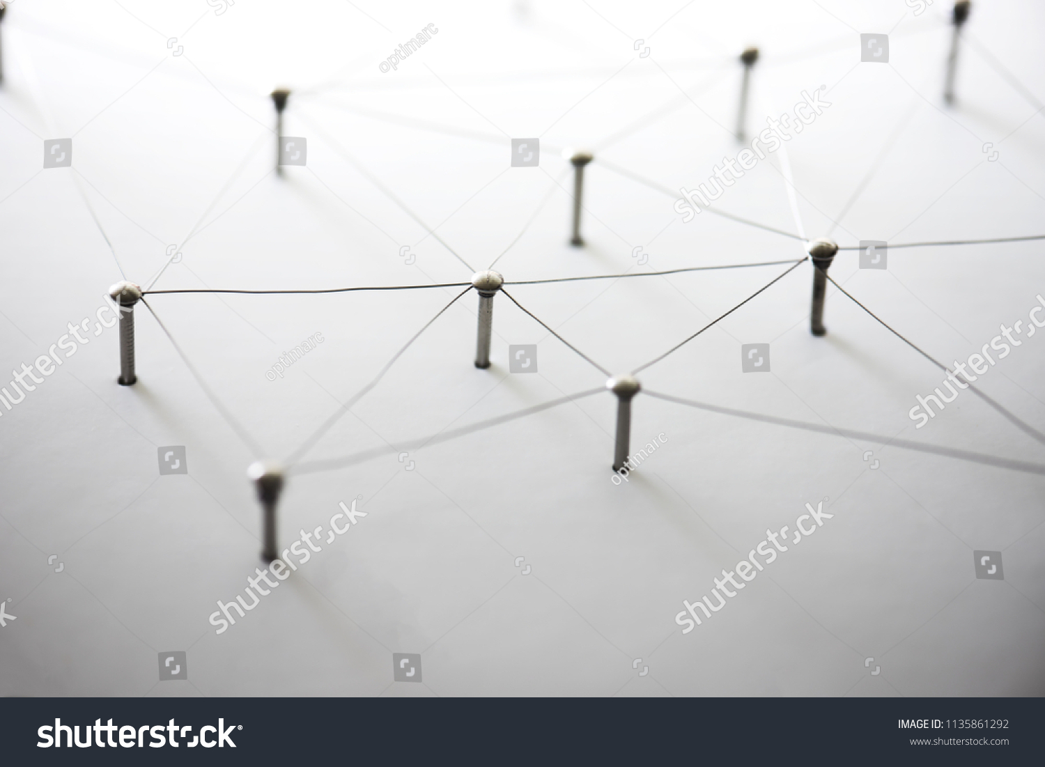 Connecting people and machines. Networking, internet infrastructure communication abstract. Entities of a network connected to each other. Web of thin silver wires on white background. #1135861292