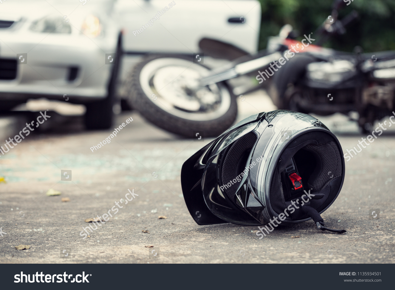Close-up of a helmet of a driver with a blurred motorbike and car in the background #1135934501