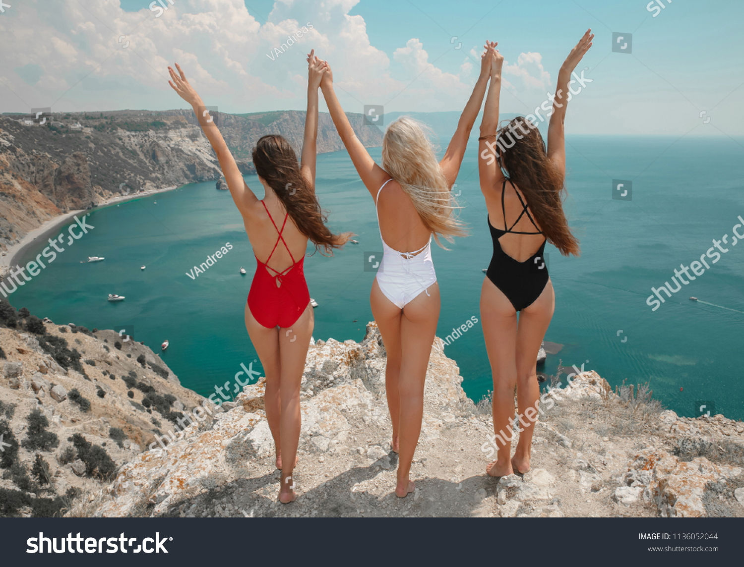 Free three bestgirlfriends with open arms. Fashion women bikini clothes set. Beautiful traveller girl friends having fun in trendy outfit on cliff mountains enjoying lagoon bay. Summertime vacation. #1136052044