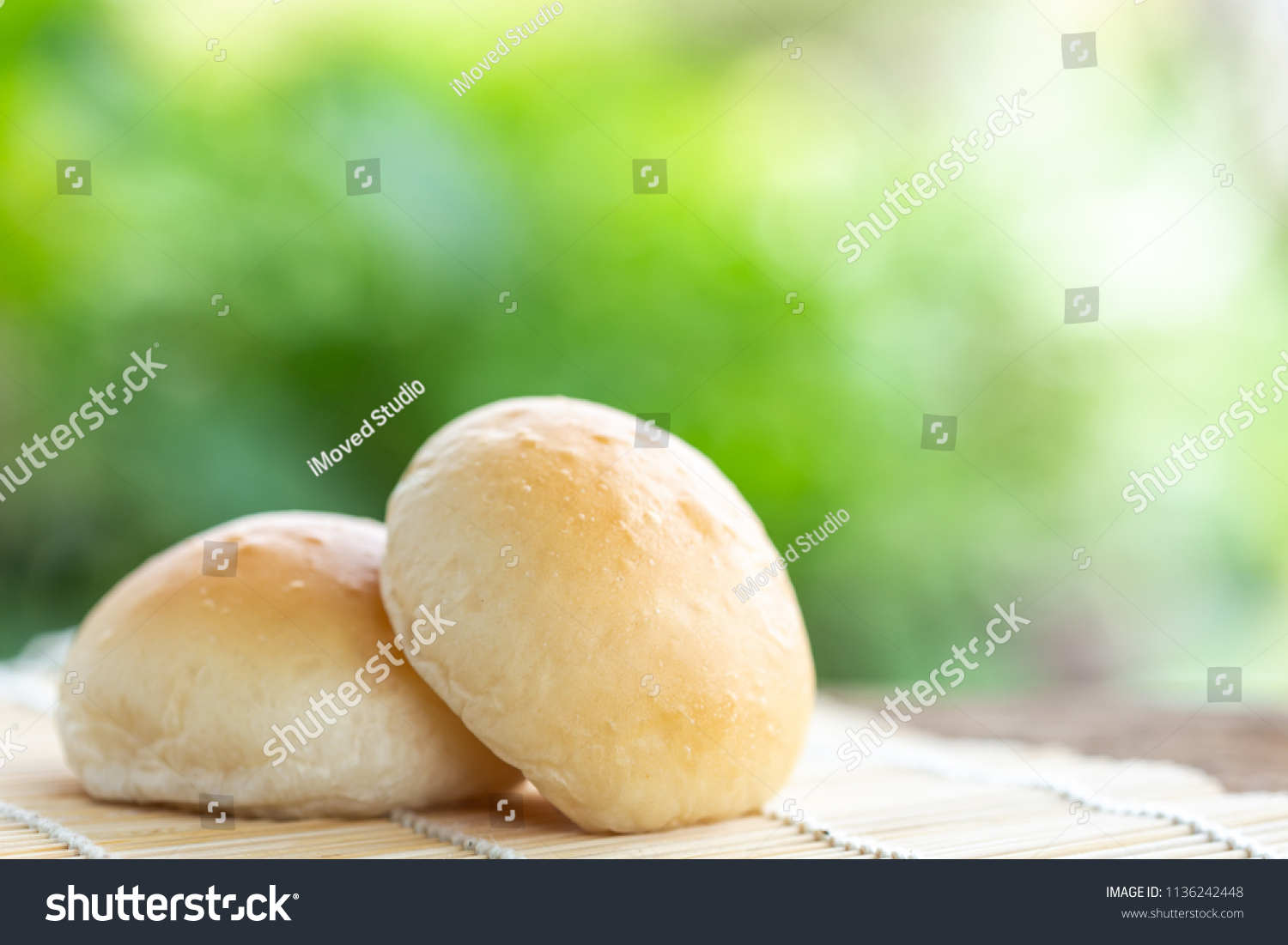 Close up two of bread on wooden table with green blur light background. Food concept #1136242448