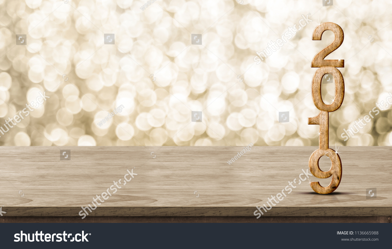 Happy New Year 2019 wood with sparkling star on brown wood table with gold bokeh background,Holiday festive celebration concept.Banner mock up for display of product or design content #1136665988
