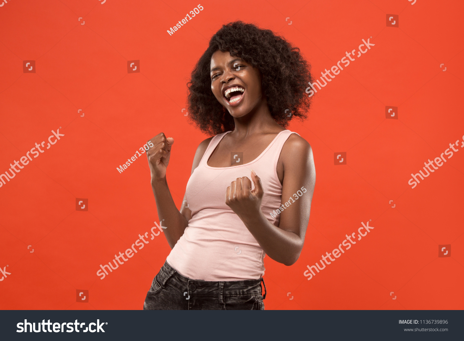 I won. Winning success happy woman celebrating being a winner. Dynamic image of caucasian female model on red studio background. Victory, delight concept. Human facial emotions concept. Trendy colors #1136739896