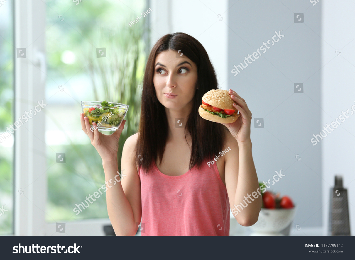 Woman with tasty burger and fresh salad indoors. Choice between healthy and unhealthy food #1137799142