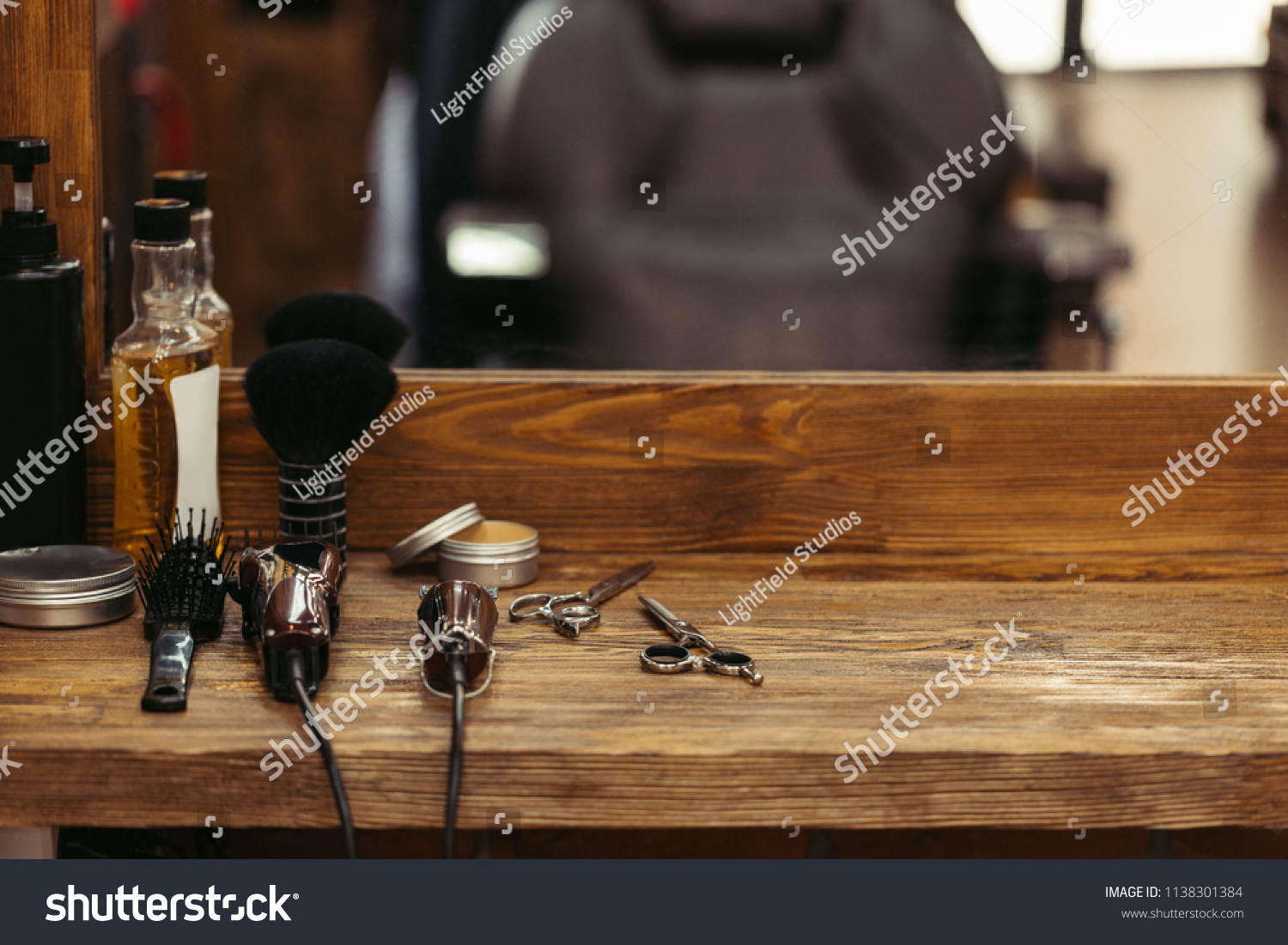 barber tools on wooden shelf and mirror in barbershop #1138301384