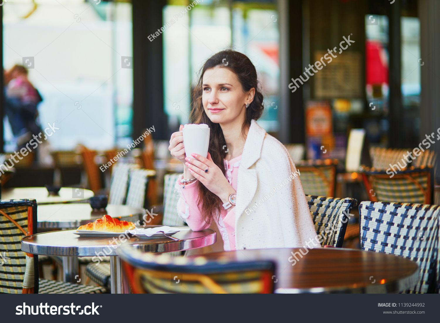 Beautiful young woman drinking coffee in outdoor cafe or restaurant, Paris, France #1139244992