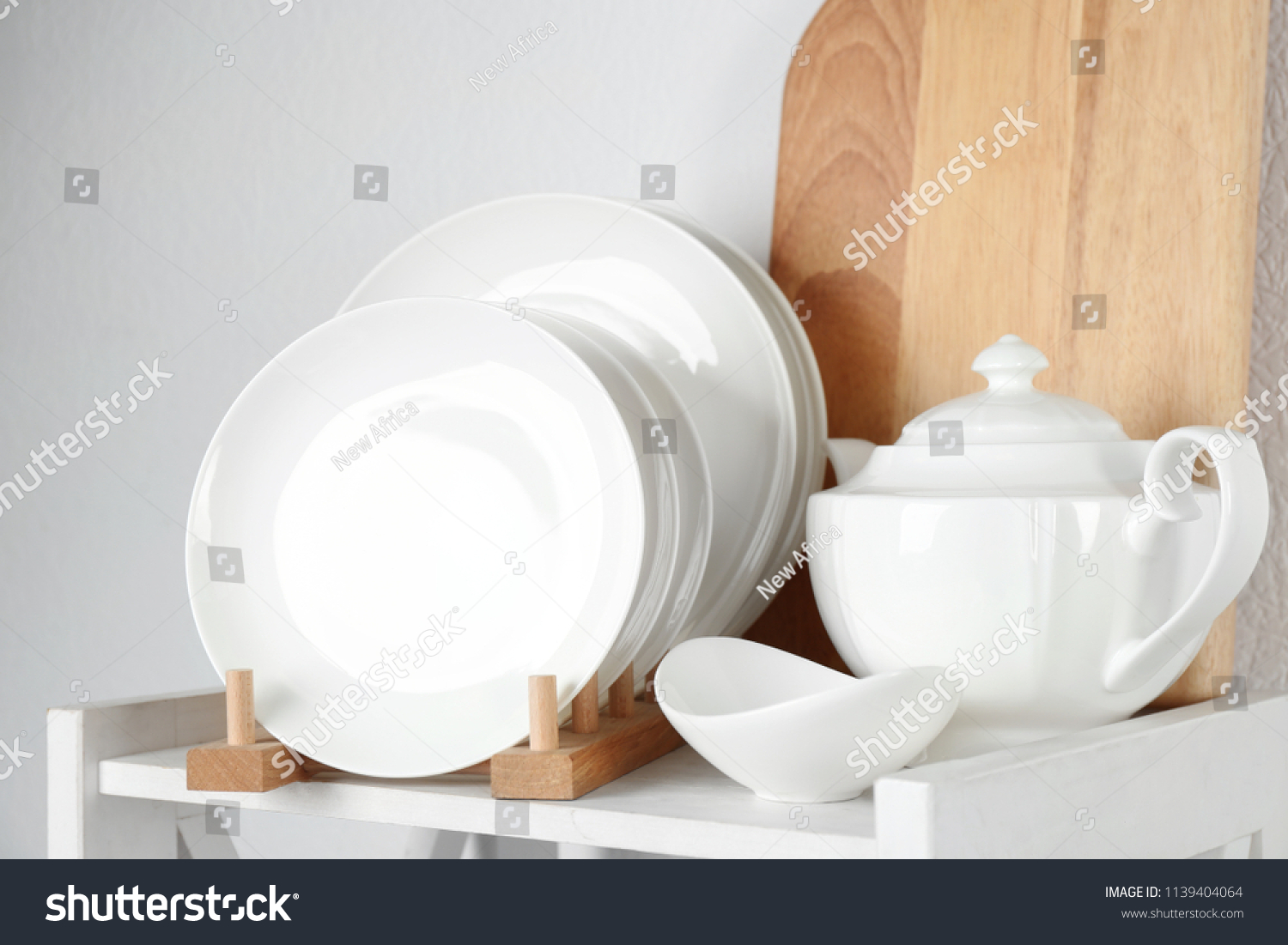 Different clean tableware on shelf in kitchen #1139404064