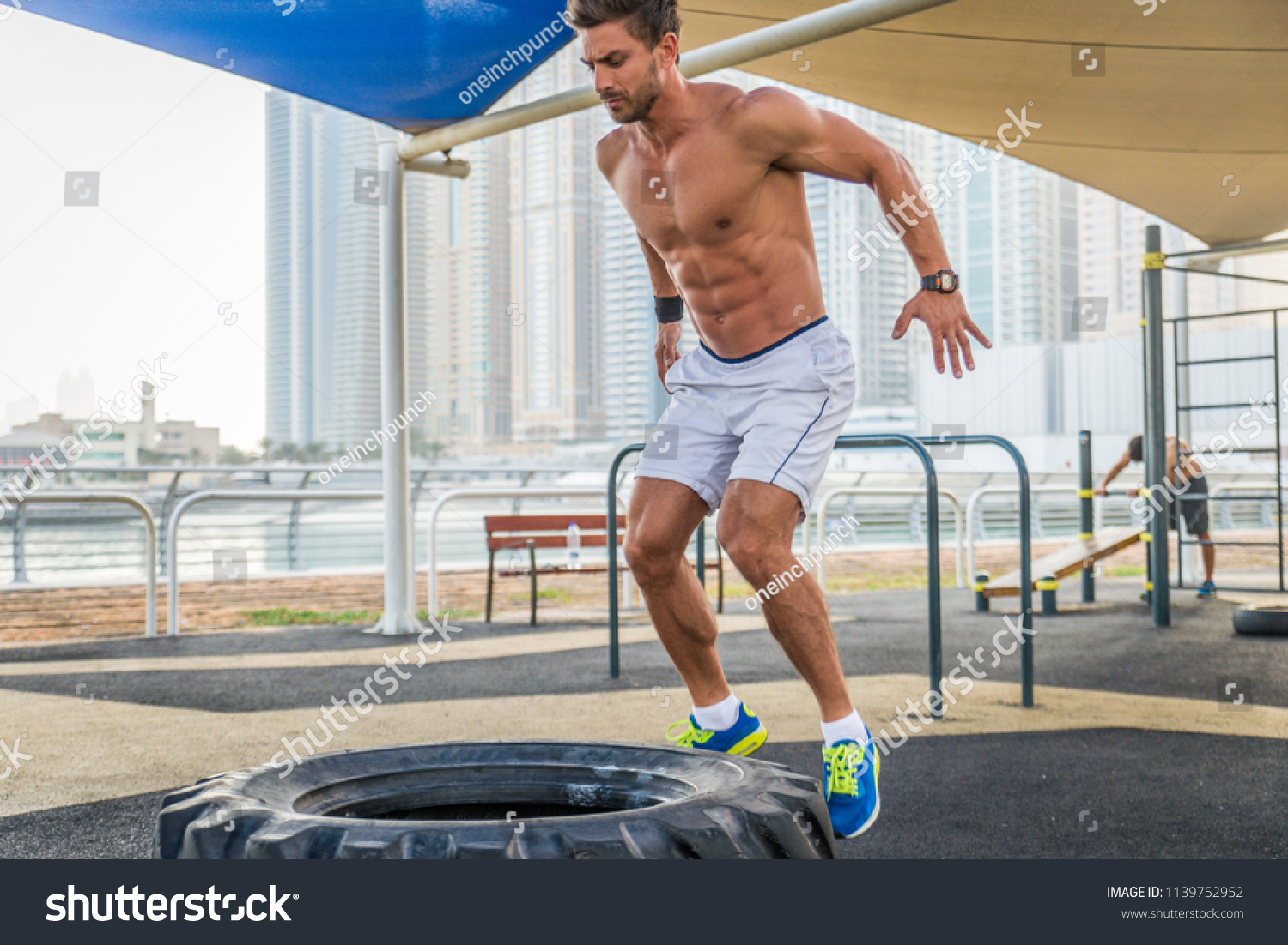 Young athletic man training outdoors - Young adult doing a fitness workout #1139752952