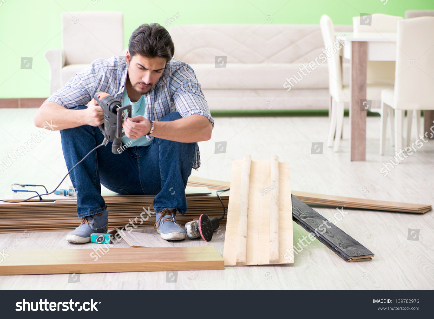 Man laying flooring at home #1139782976