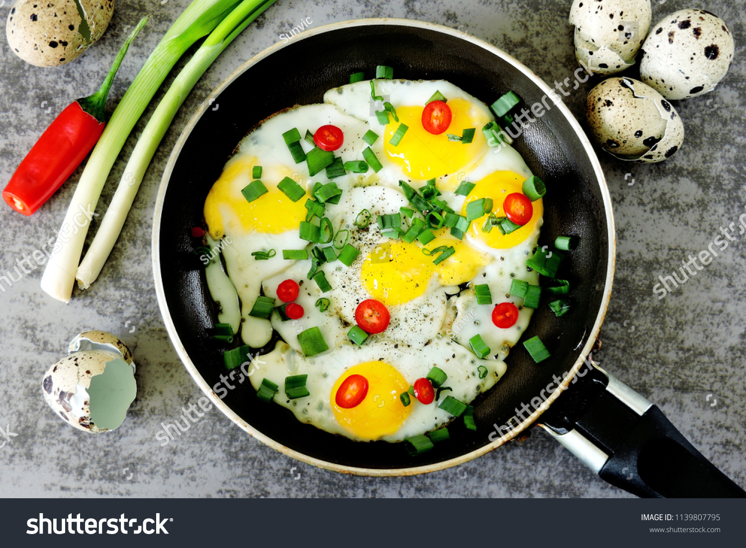 Fried quail eggs with greens and chili peppers in a skillet. Keto diet. Keto breakfast. #1139807795