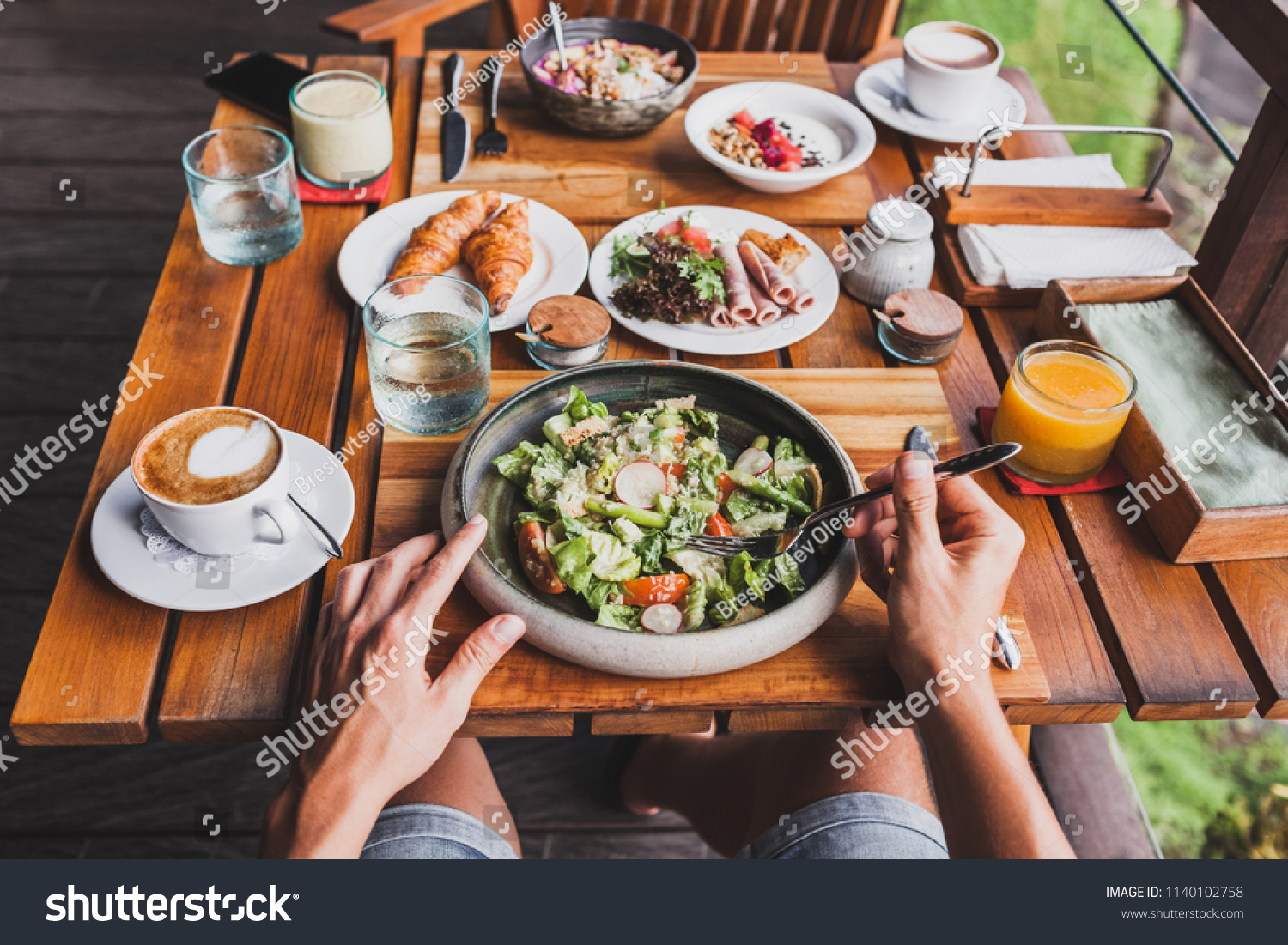 View from above on table with fresh breakfast. Man hands holding fork and knife #1140102758