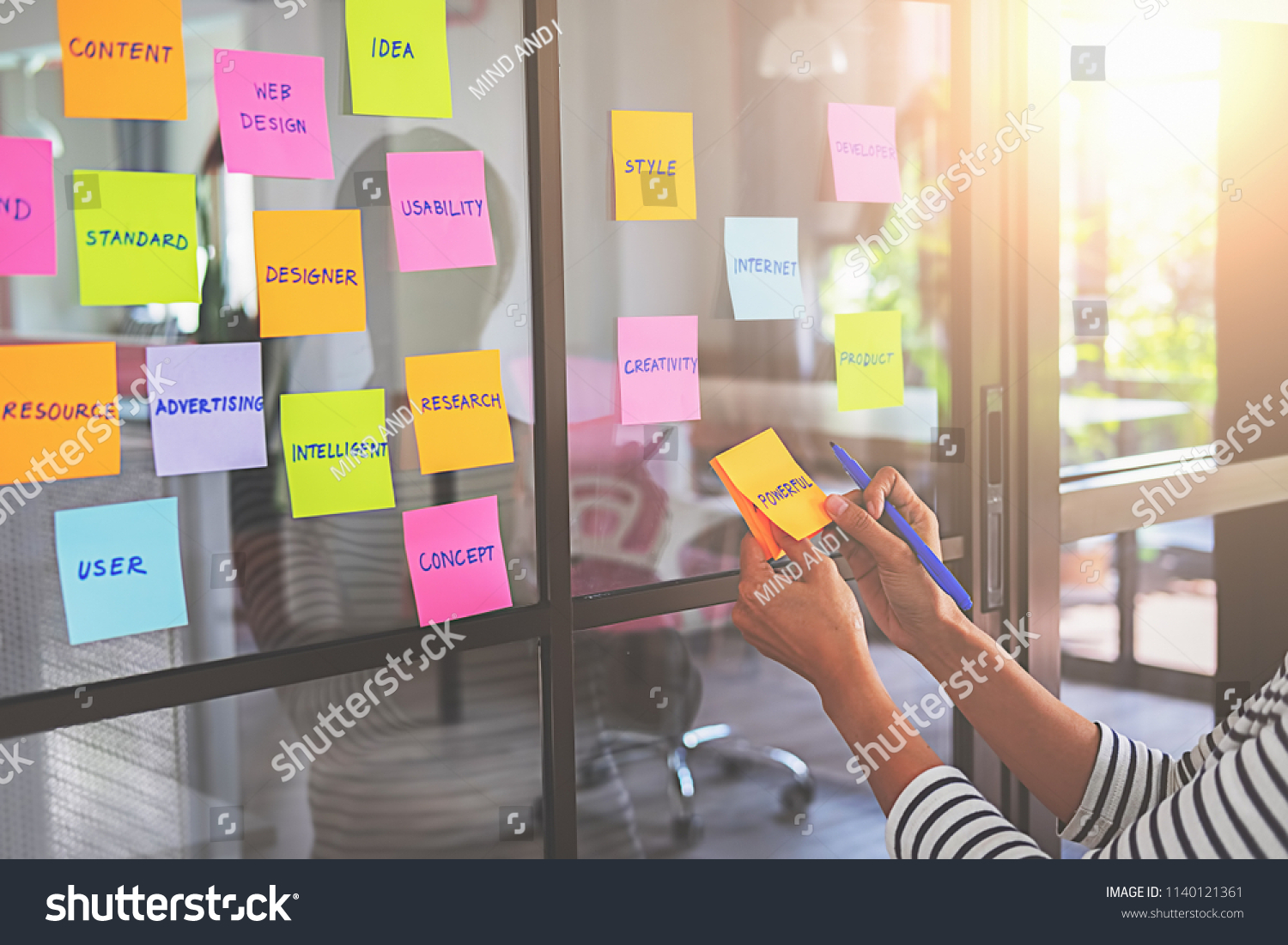 Web designer brainstorming for a strategy plan. Colorful sticky notes with things to do on office board. User experience (UX) concept. #1140121361