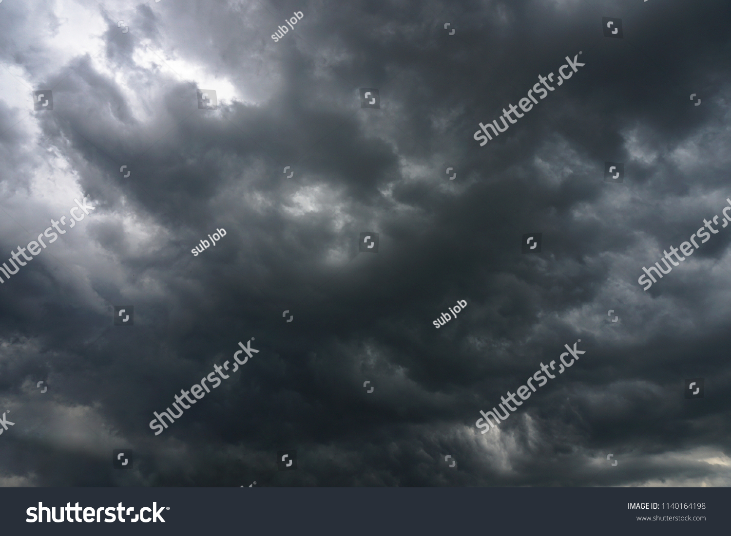 Dark, grim, stormy, rainy sky with rays of light. Scary hurricane clouds. Natural element. Stock Photo for your design #1140164198