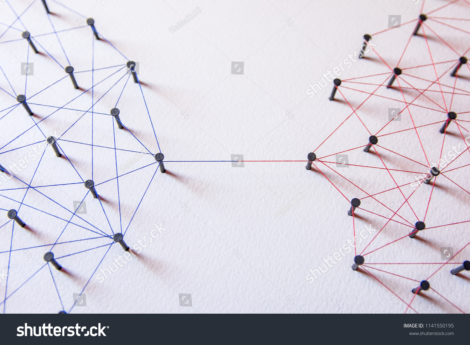 Connecting networks concept - two network connected with yarn red and blue on white paper. Simulator connection social media, internet, people communication #1141550195