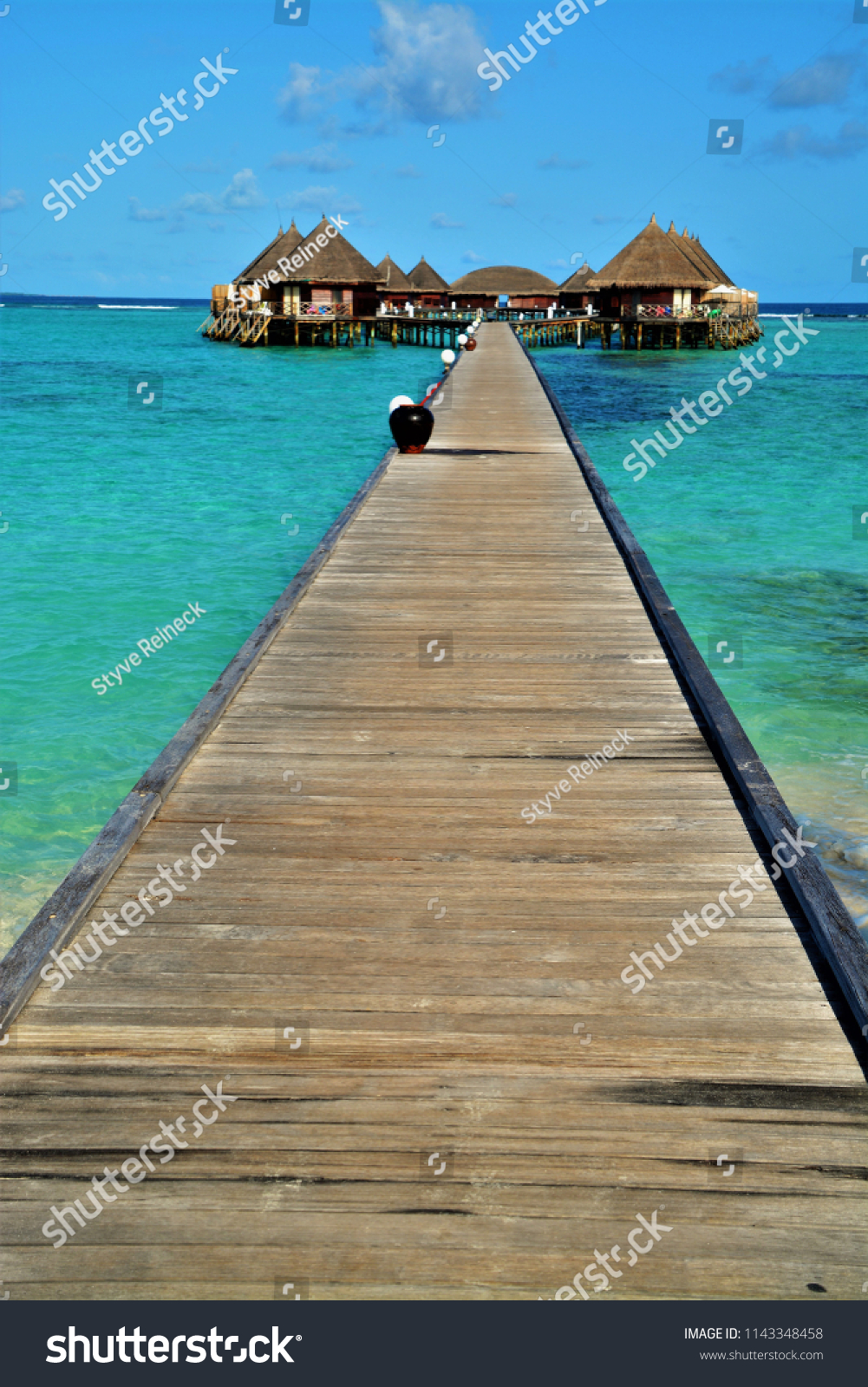 over water bungalows in turquoise lagoon on a luxury island on maldives #1143348458