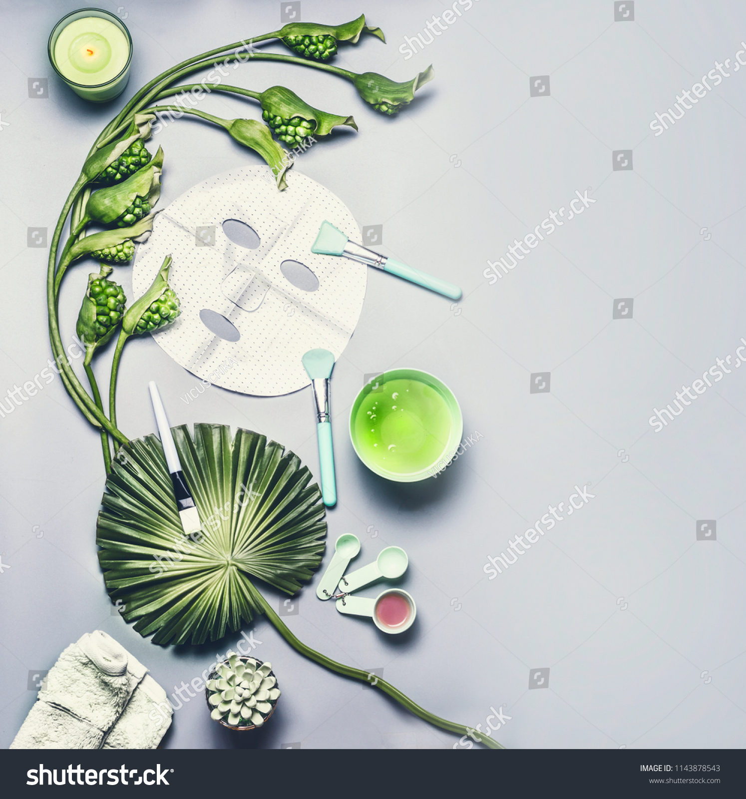 Skin care cosmetic and facial sheet mask. Various serum, cream and gel cosmetics product with tropical leaves and flowers on gray background, top view with copy space. Beauty concept #1143878543