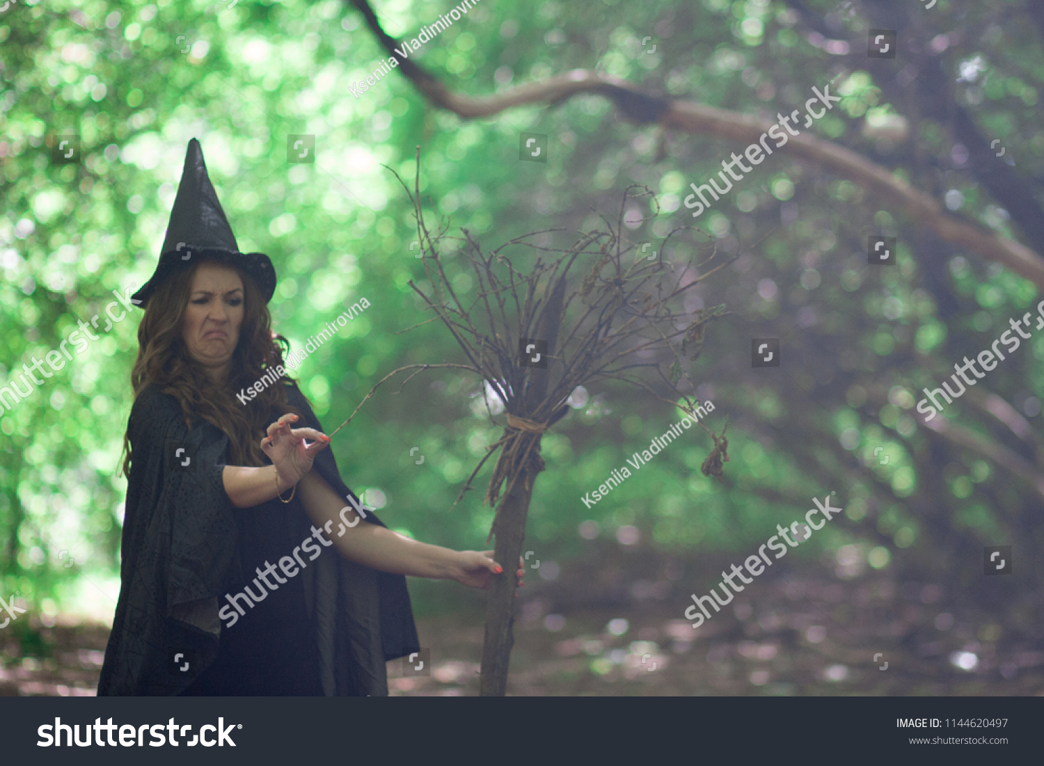Halloween. The witch is funny. The old broom. The broom broke. The squeamish witch in the hood of the witch #1144620497