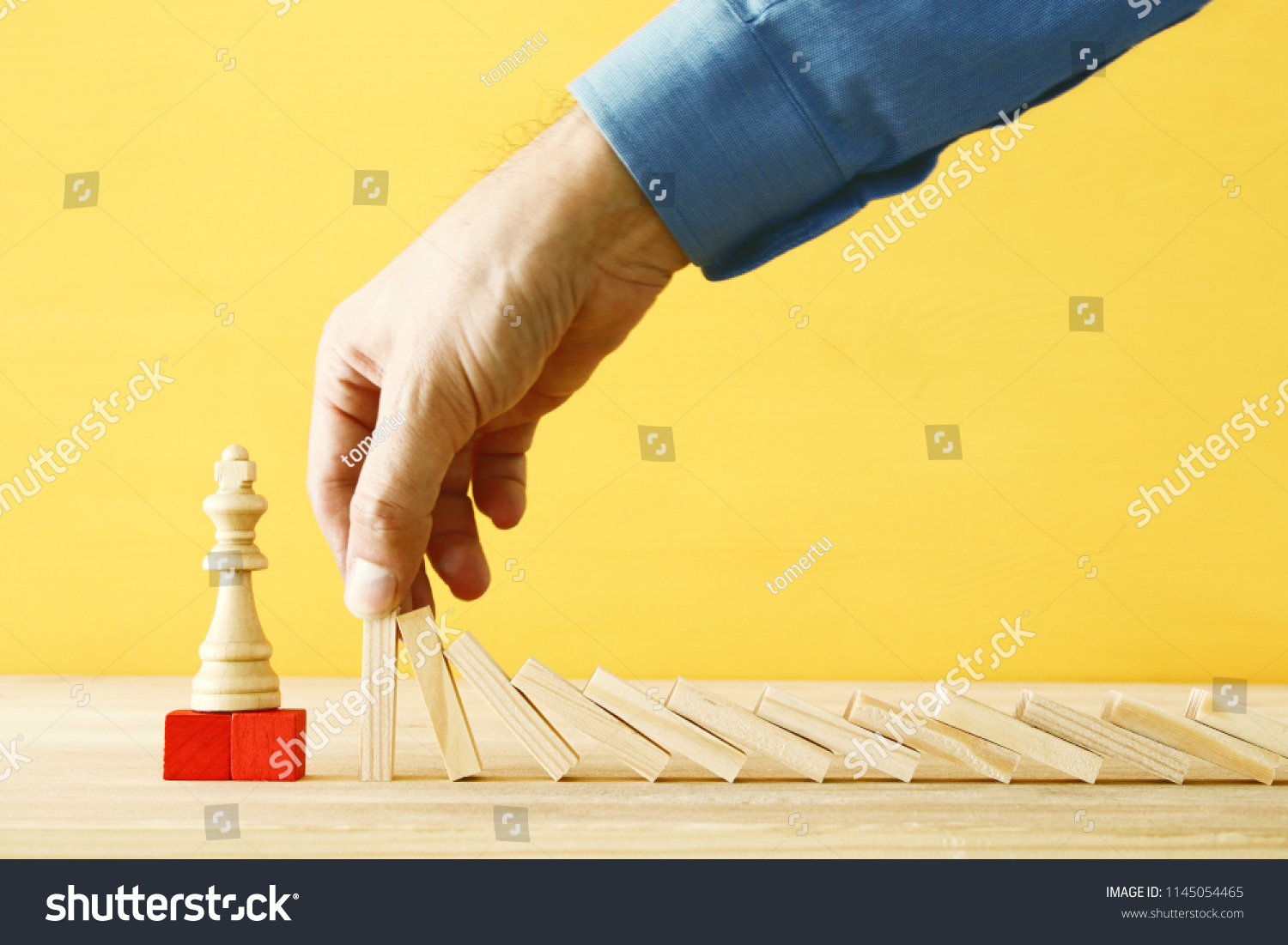 image of male hand stopping the domino effect. executive and risk control concept #1145054465