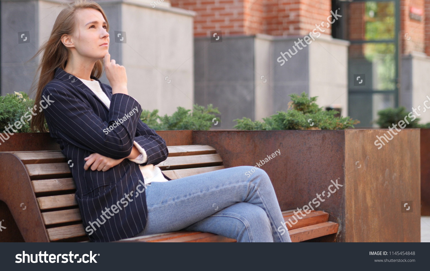 Pensive Business Woman Thinking while Sitting Outside Office on Bench #1145454848
