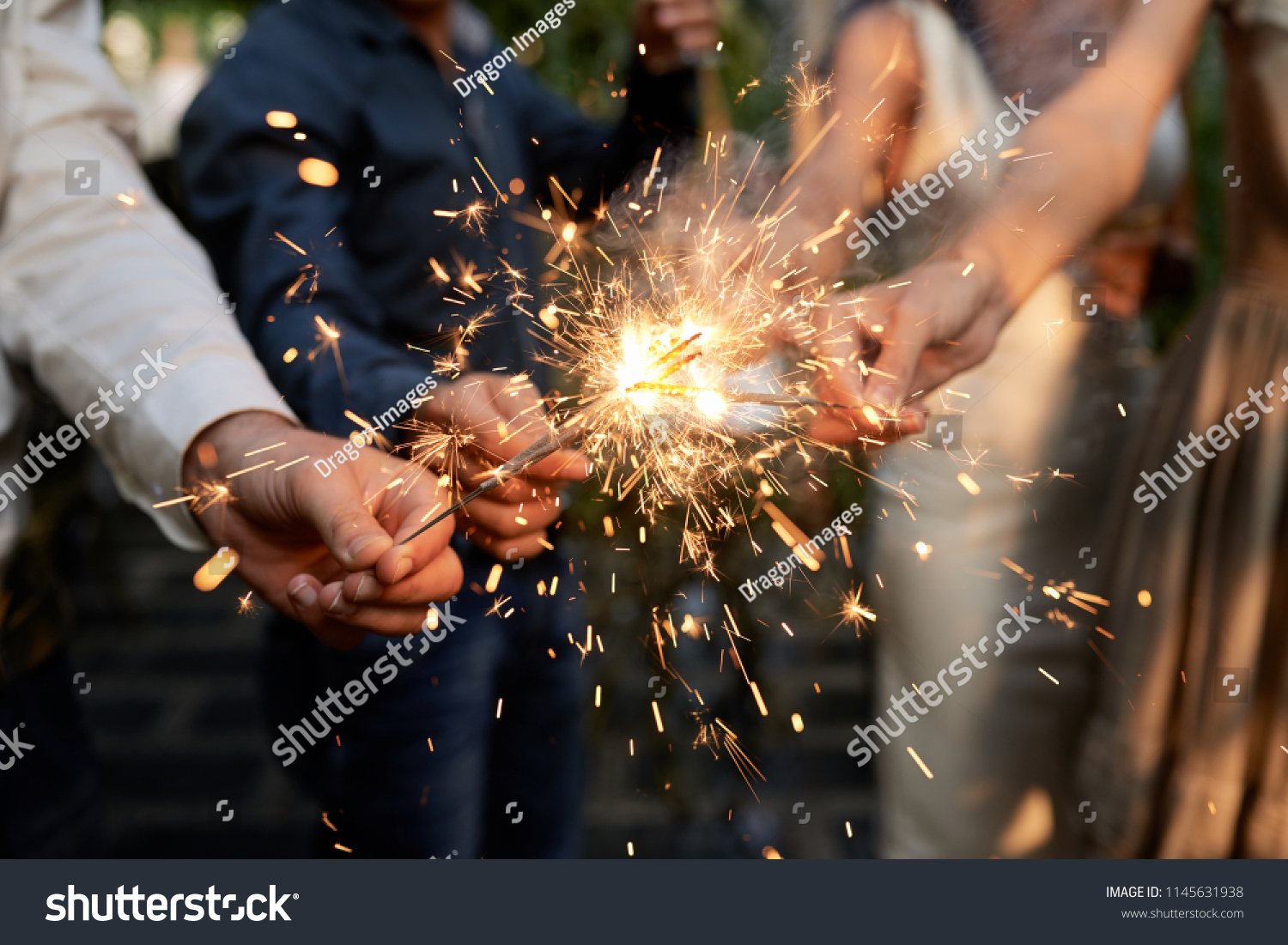 Burning sparklers in hands of party guests #1145631938