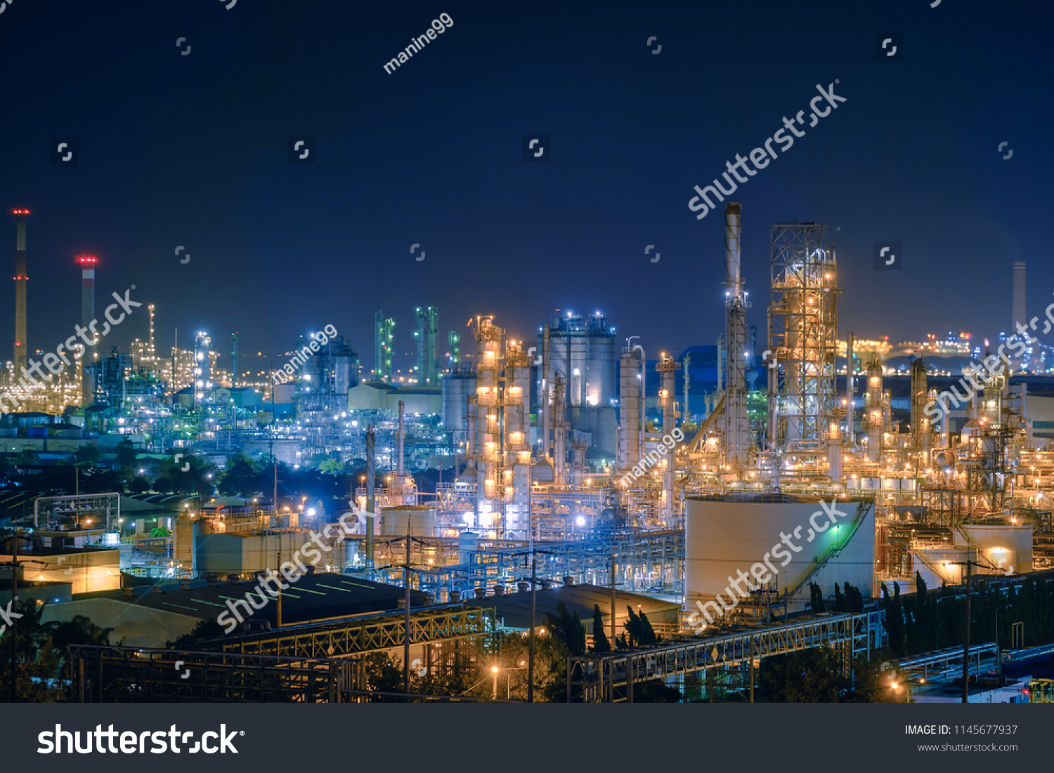 Oil and Gas refinery industry plant with glitter lighting, Factory of petroleum industrial at night time, Petrochemical plant with gas distillation tower and storage tank #1145677937