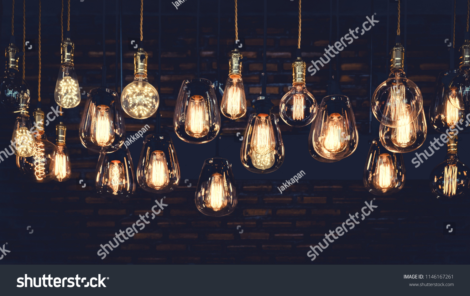 Beautiful vintage luxury light bulb hanging decor glowing in dark. Retro filter effect style. #1146167261