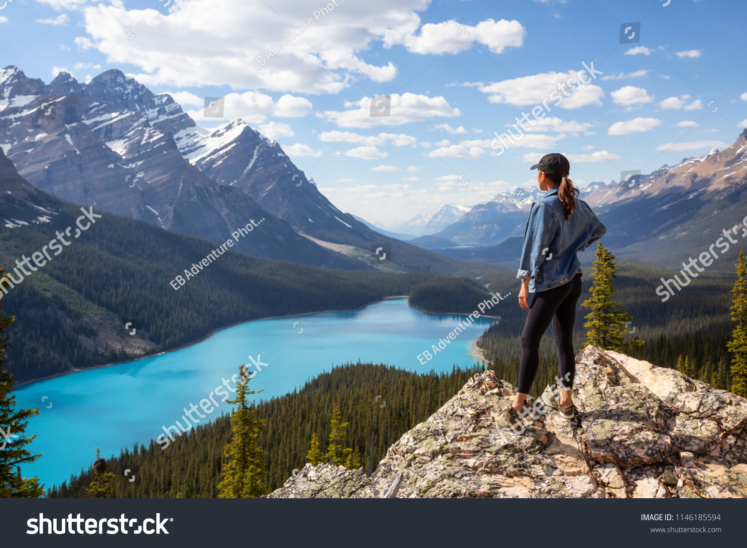 Young girl enjoying the beautiful Canadian Rockies Landscape view during a vibrant sunny summer day. Taken in Peyto Lake, Banff National Park, Alberta, Canada. #1146185594