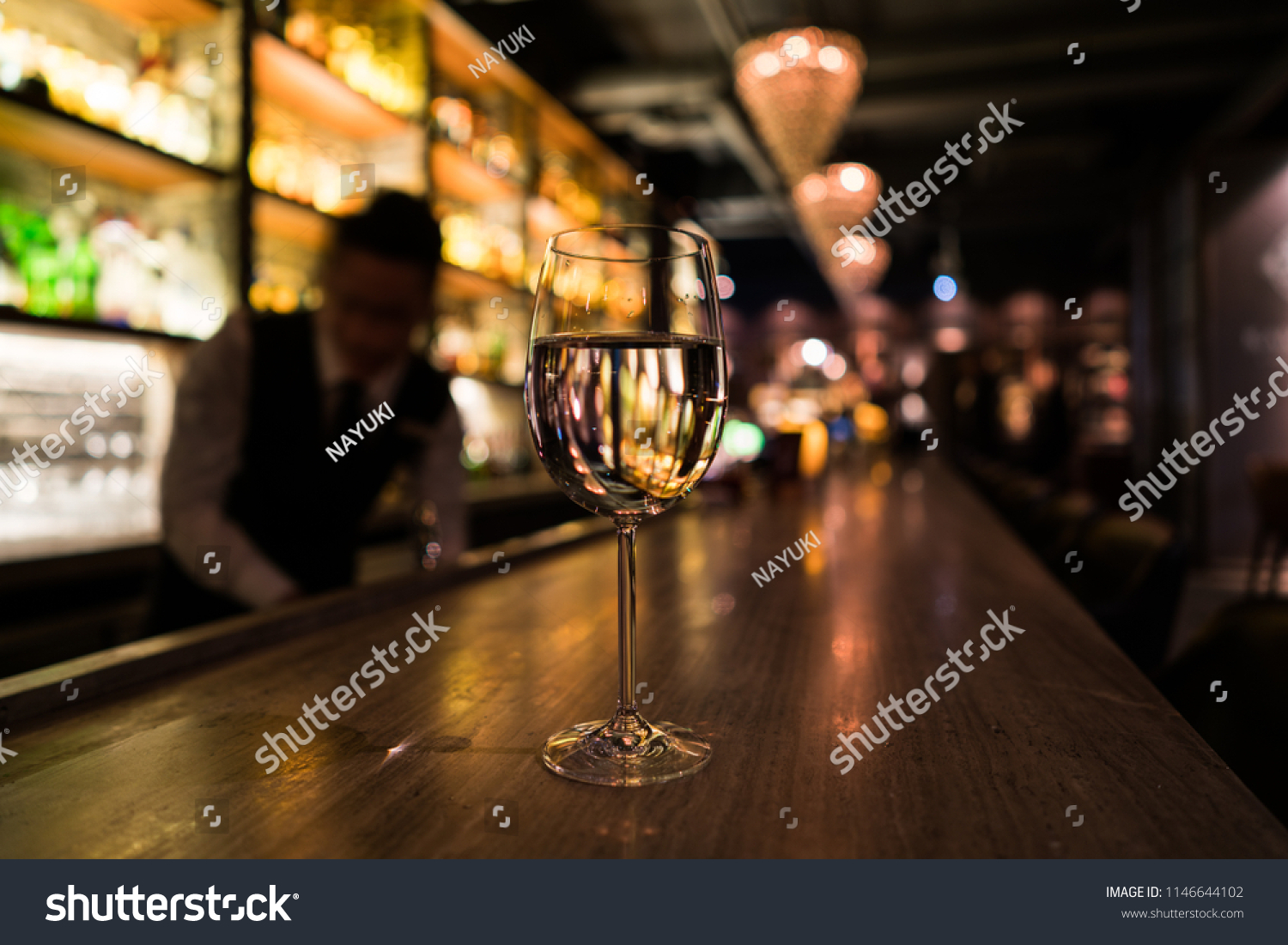 A glass of white wine on the bar counter #1146644102
