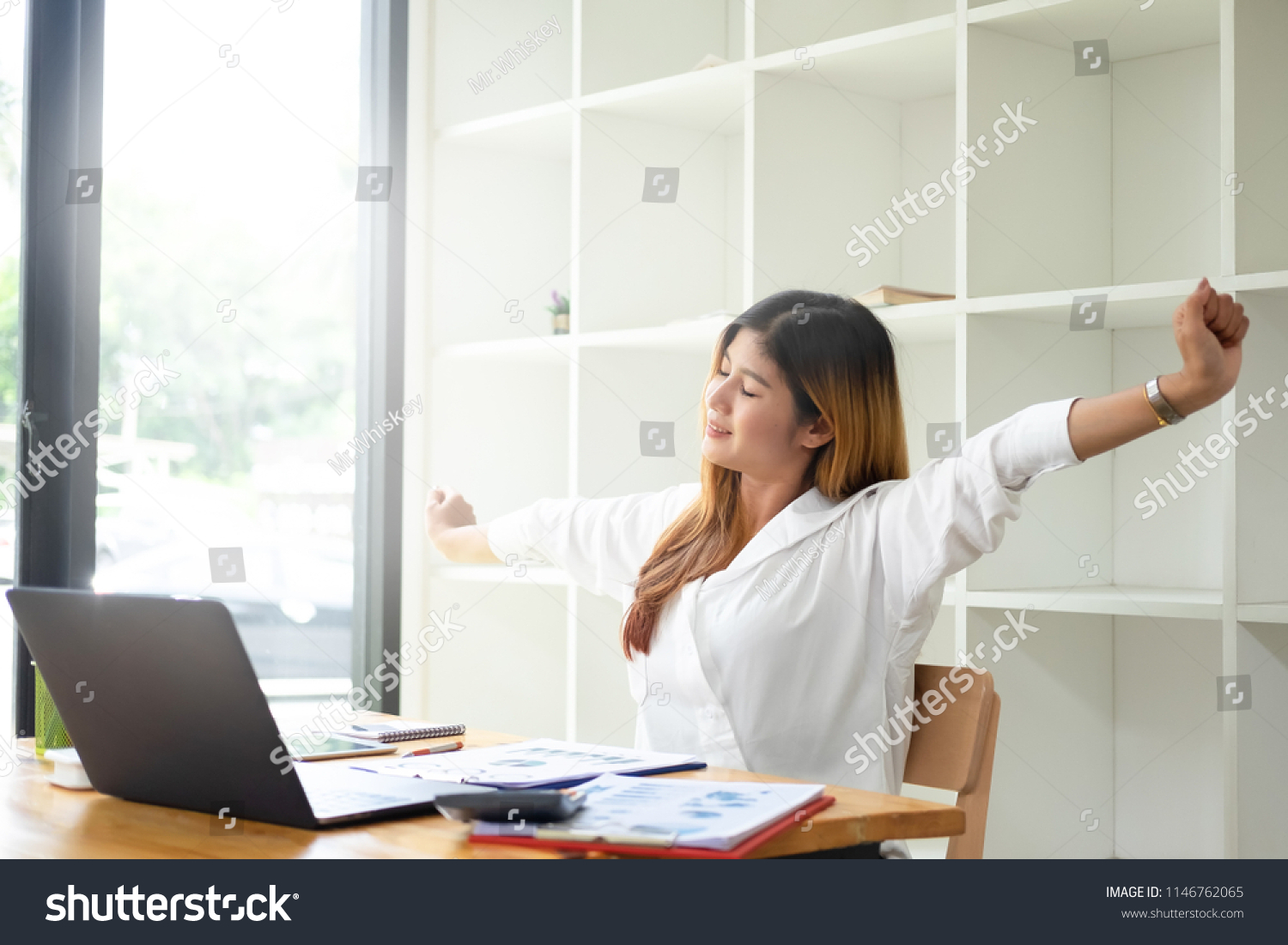 Smiling businesswoman relaxing at chair hands happy asian woman resting in office satisfied after working done. #1146762065