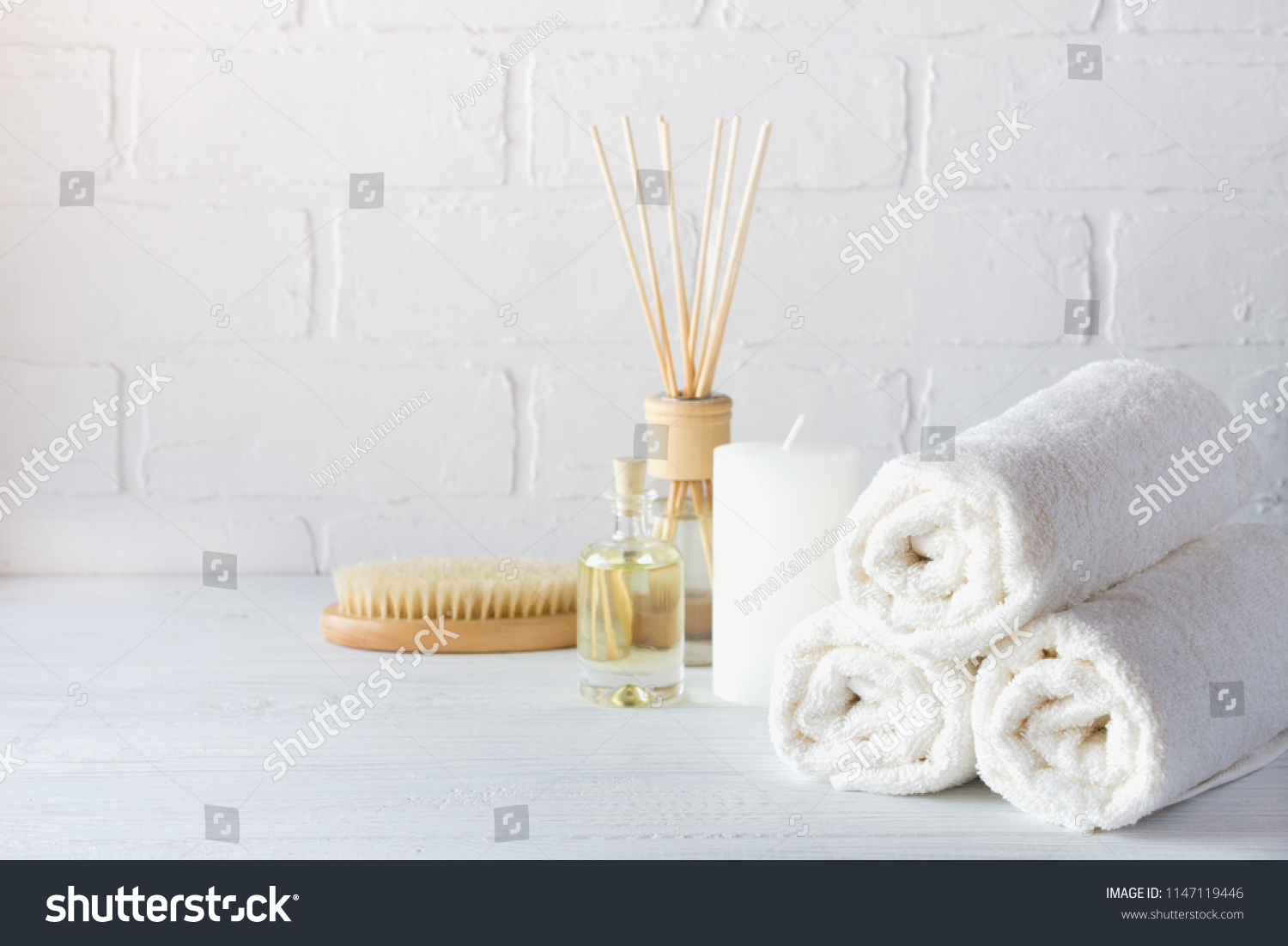 SPA aromatherapy background.  Still life with white towel, bath oil, massage brush and candle. #1147119446