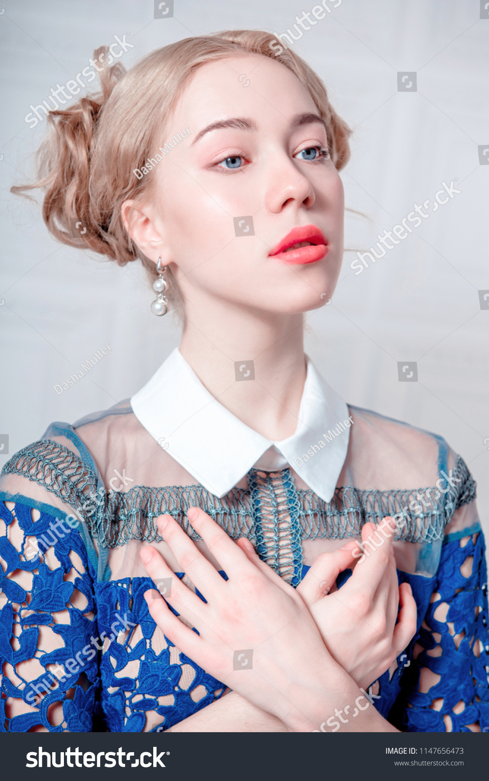 Cute young woman in navy blue dress holding bird cage, spring tender fashion studio shot #1147656473