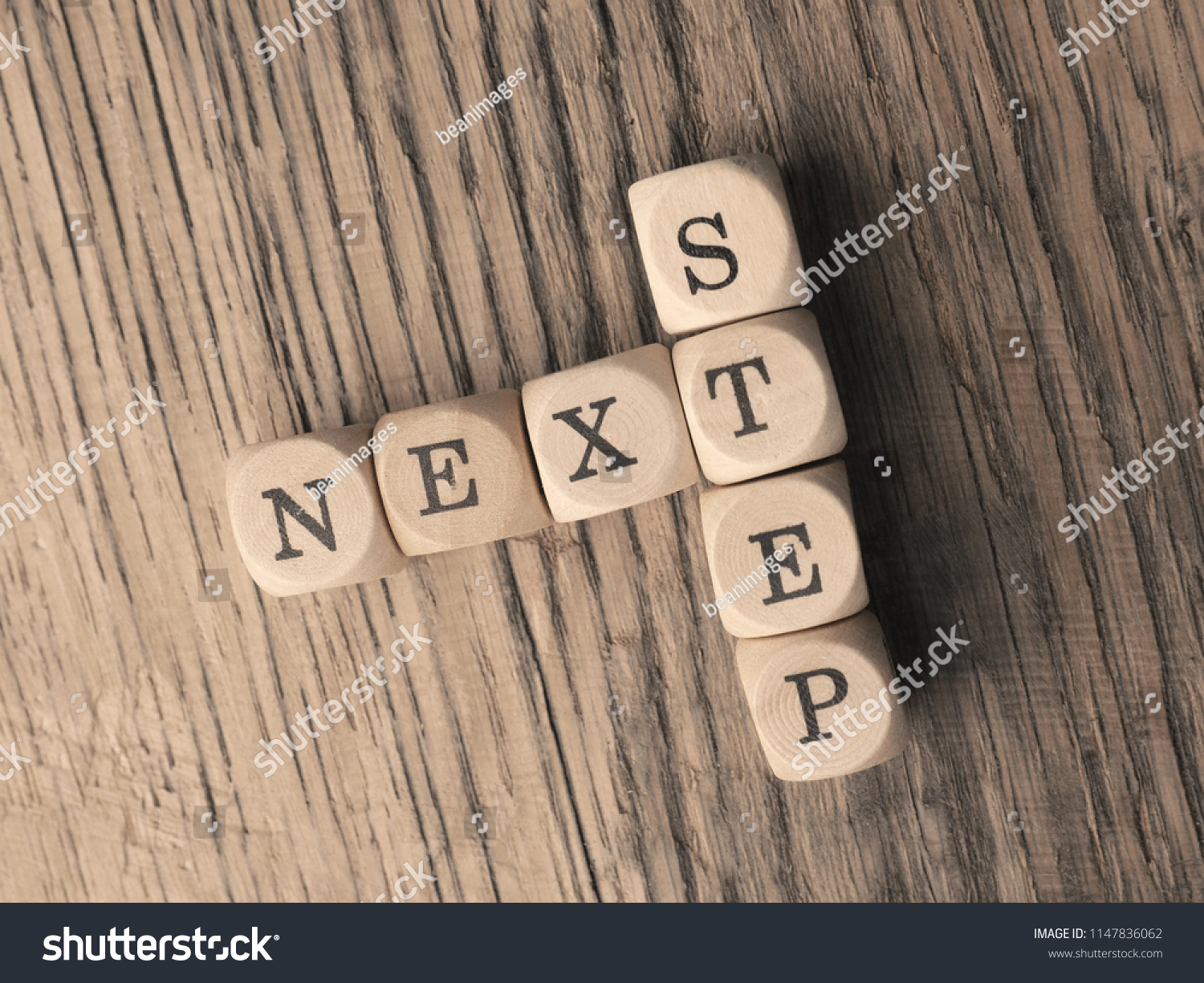 The words Next Step on small wooden dices on a table, close up shot, view from above #1147836062