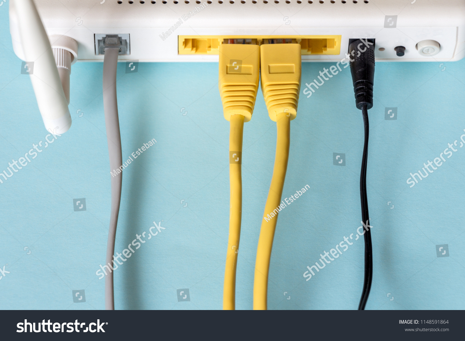 Connect an Ethernet Cable to a Wireless Router on light blue pastel. Ethernet, rj45 and electric cables, connected to router. Network concept #1148591864