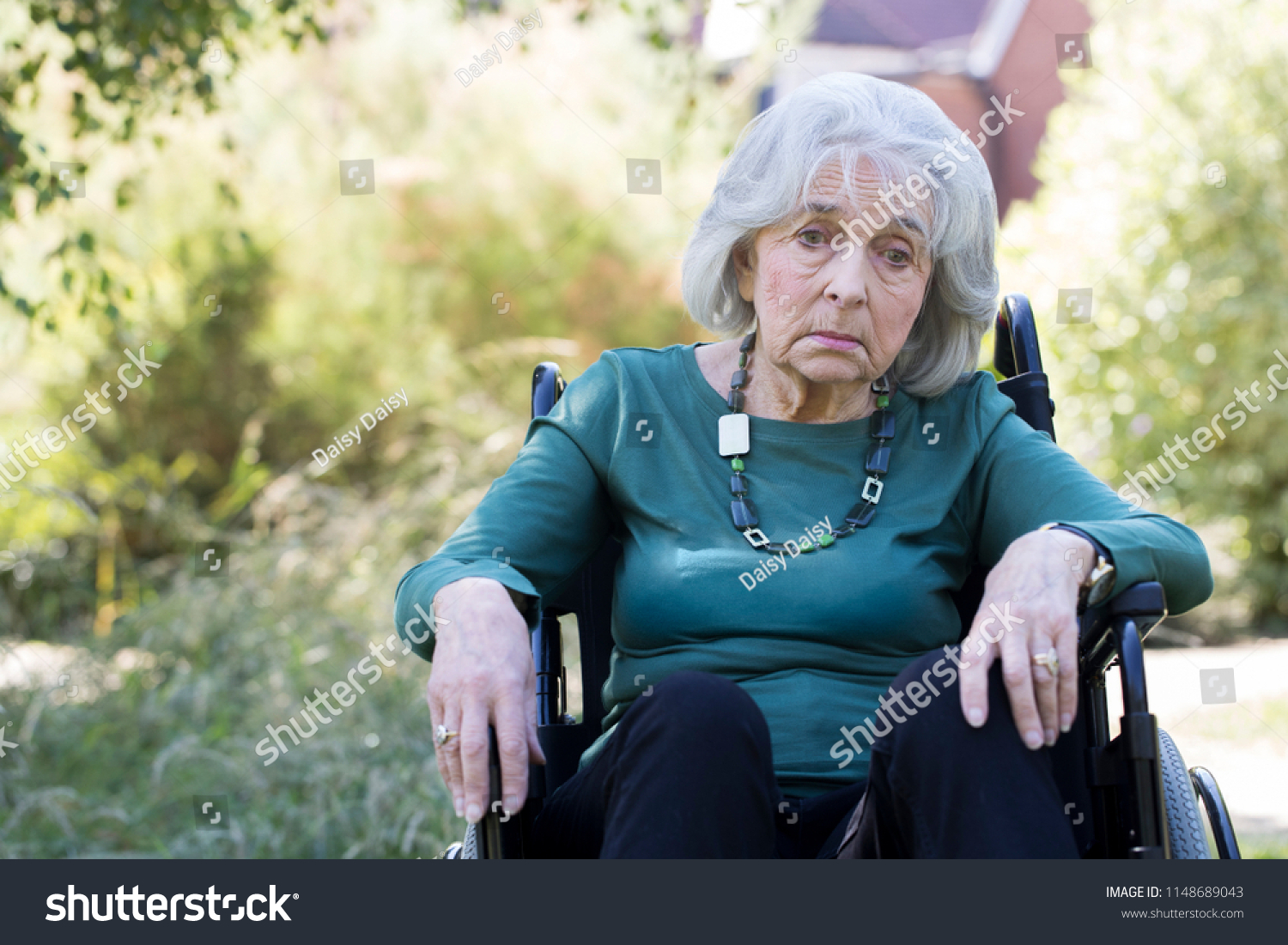 Depressed Senior Woman In Wheelchair Sitting Outdoors #1148689043
