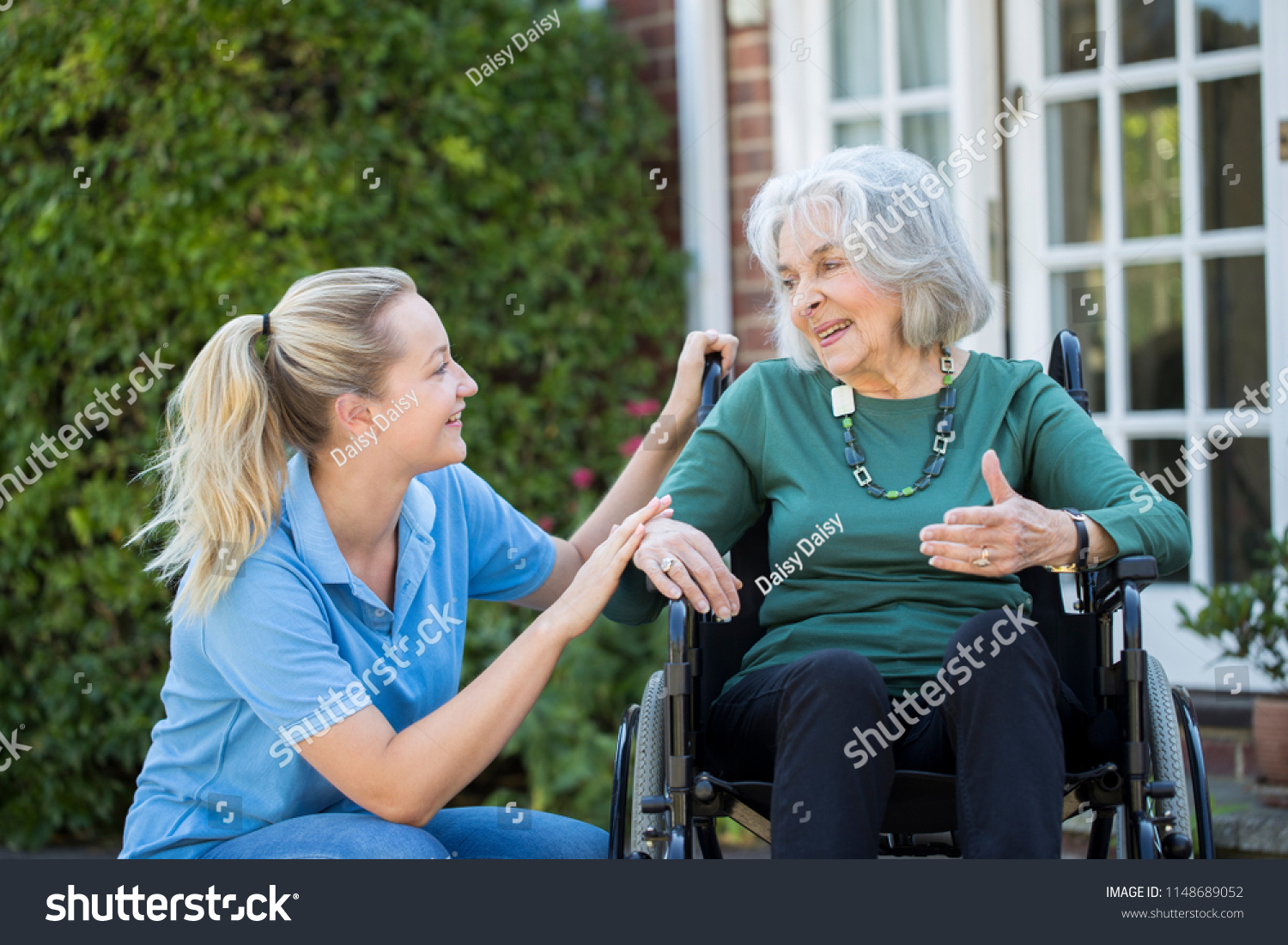 Carer Pushing Senior Woman In Wheelchair Outside Home #1148689052