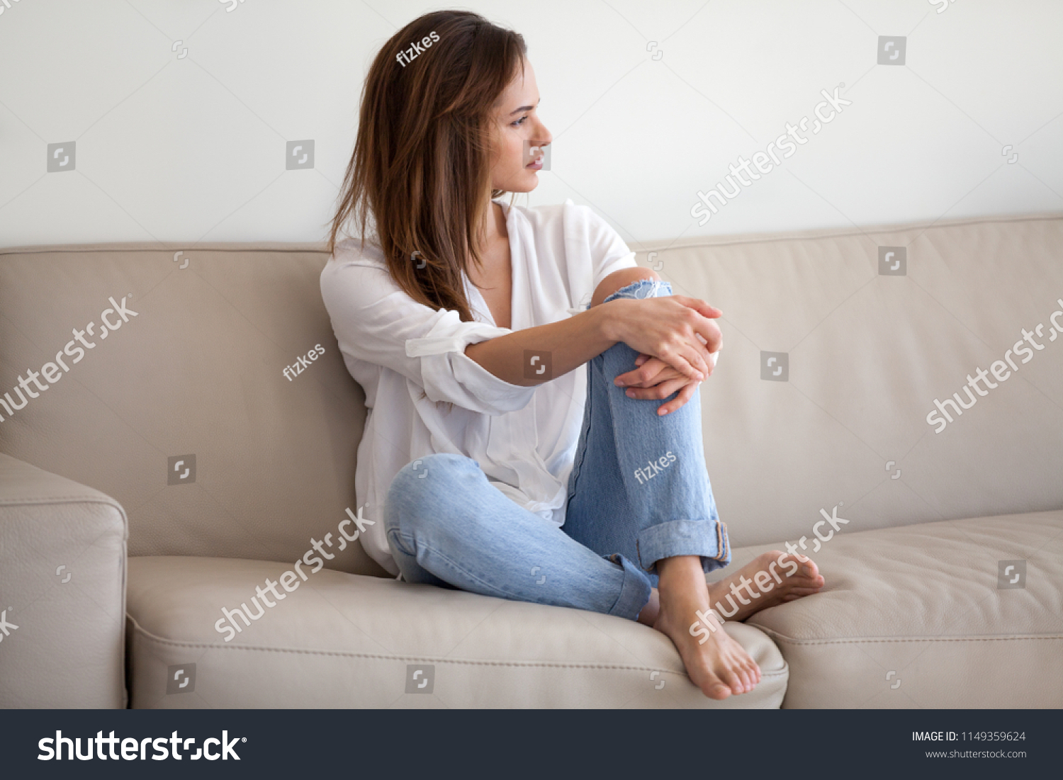 Sad millennial woman sit on couch looking far away, thinking about problems with boyfriend  #1149359624