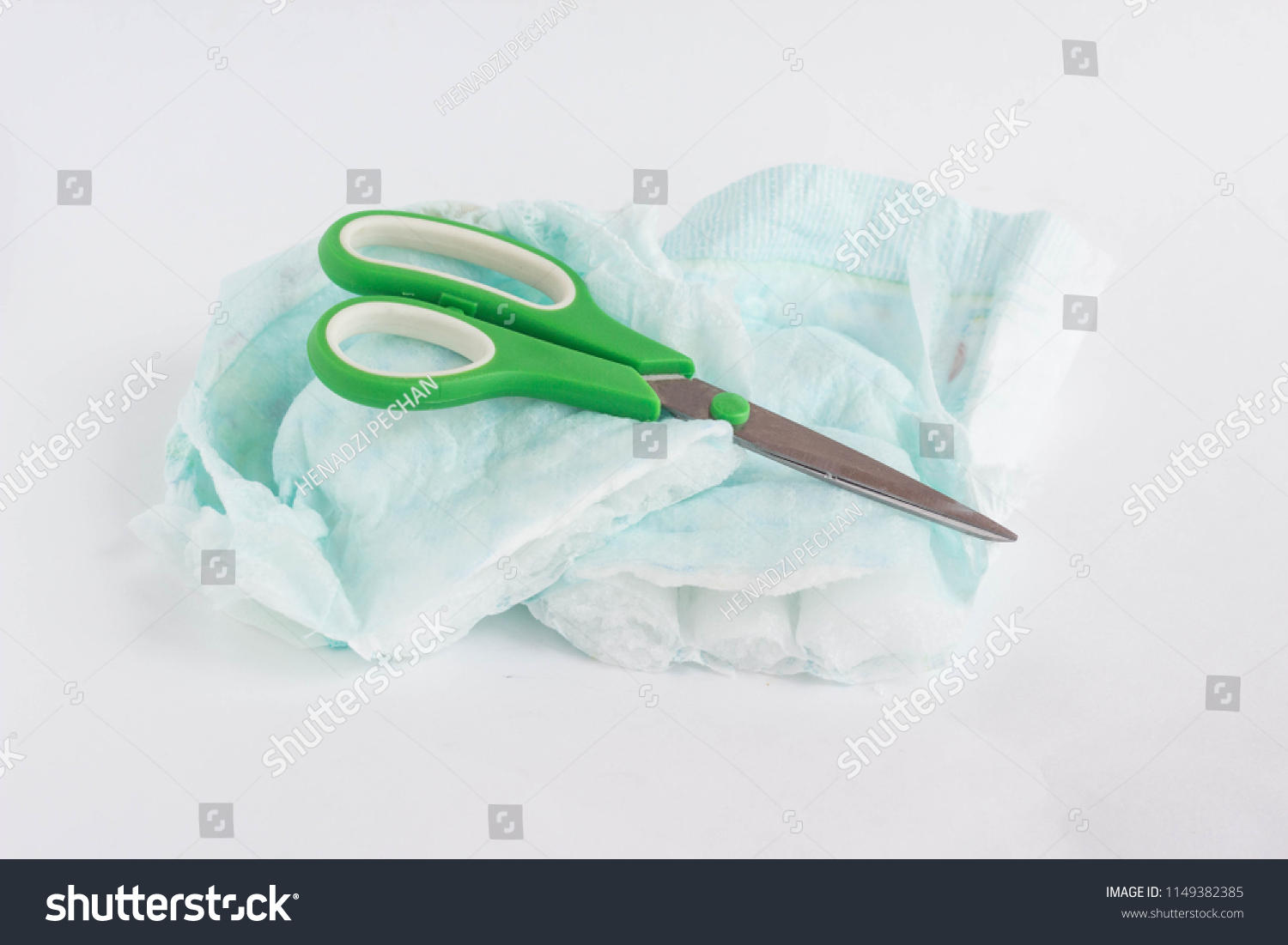 Sliced child pampers and scissors on a white background, diapers #1149382385