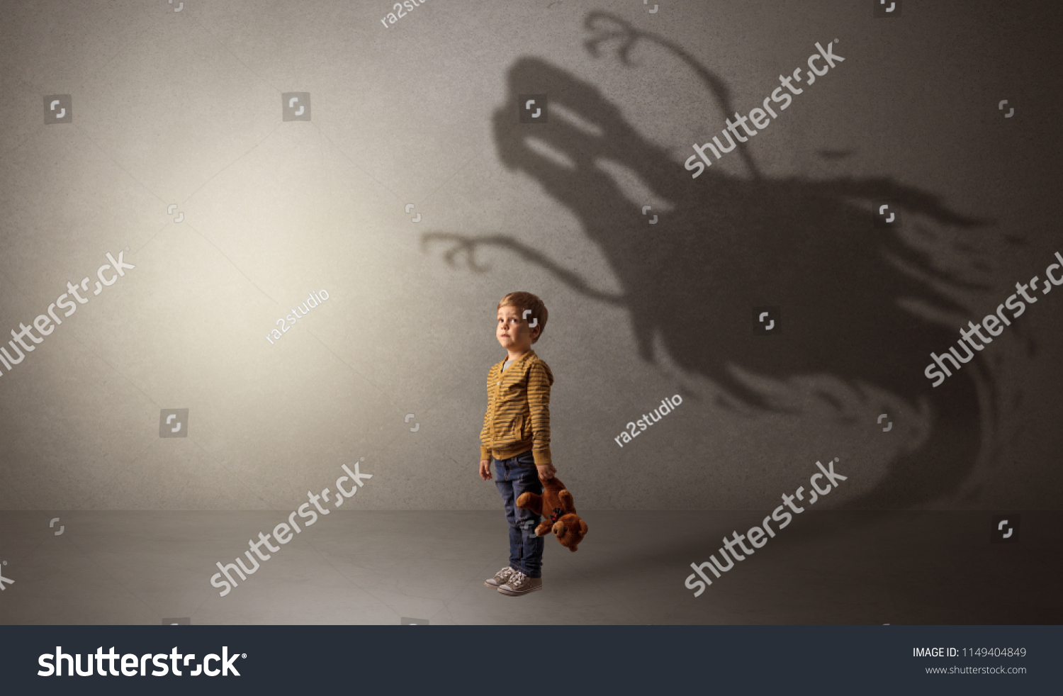 Scary ghost shadow in a dark empty room with a cute blond child #1149404849