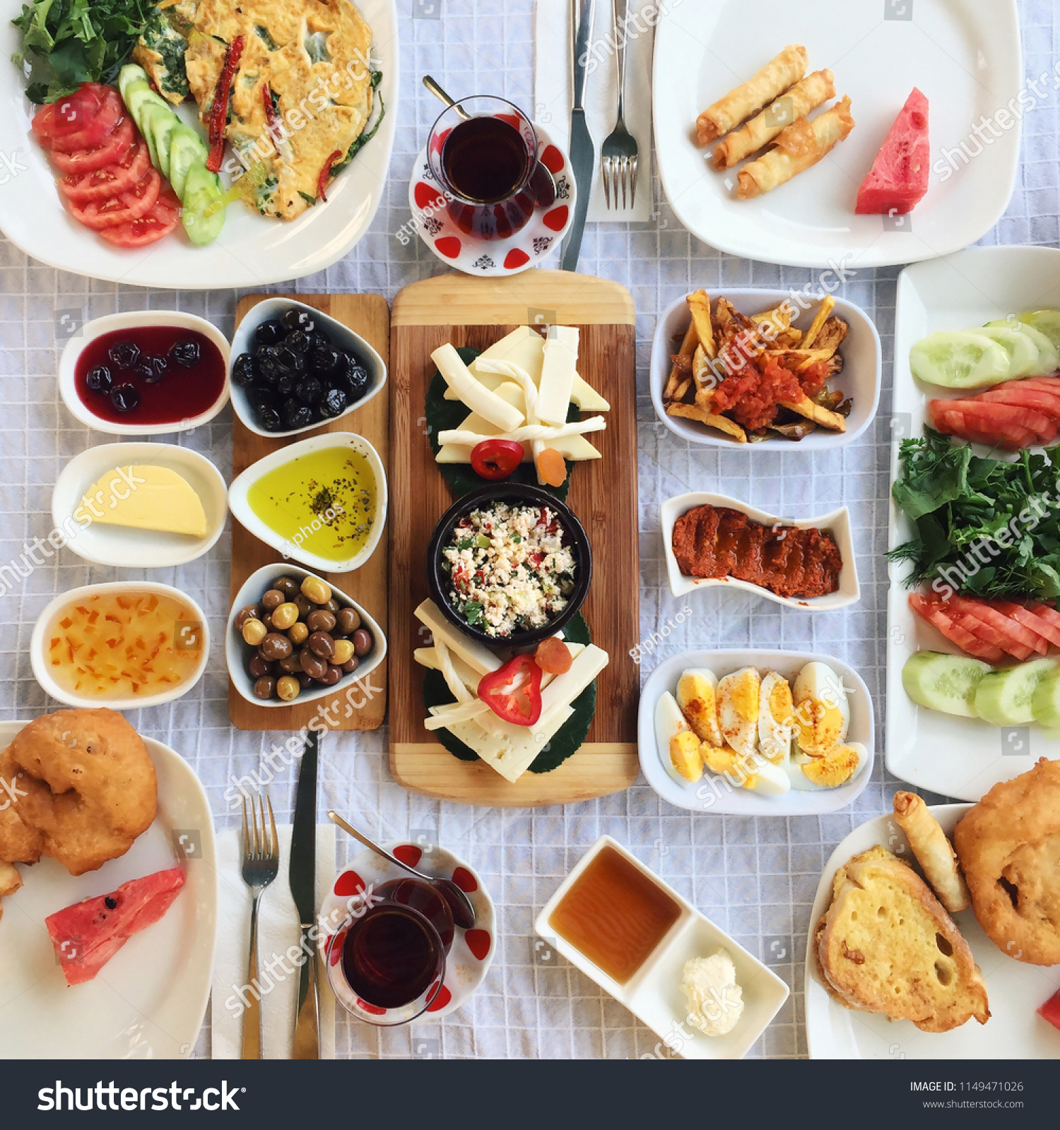 Breakfasts are usually rich in Turkish cuisine and include a lot of varieties; here in the photo there is butter, green and black olives, different jams, honey, cheese varieties, boiled eggs etc #1149471026