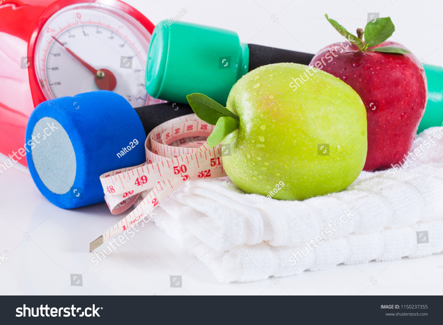 Dumbells with measuring tape and apples #1150237355