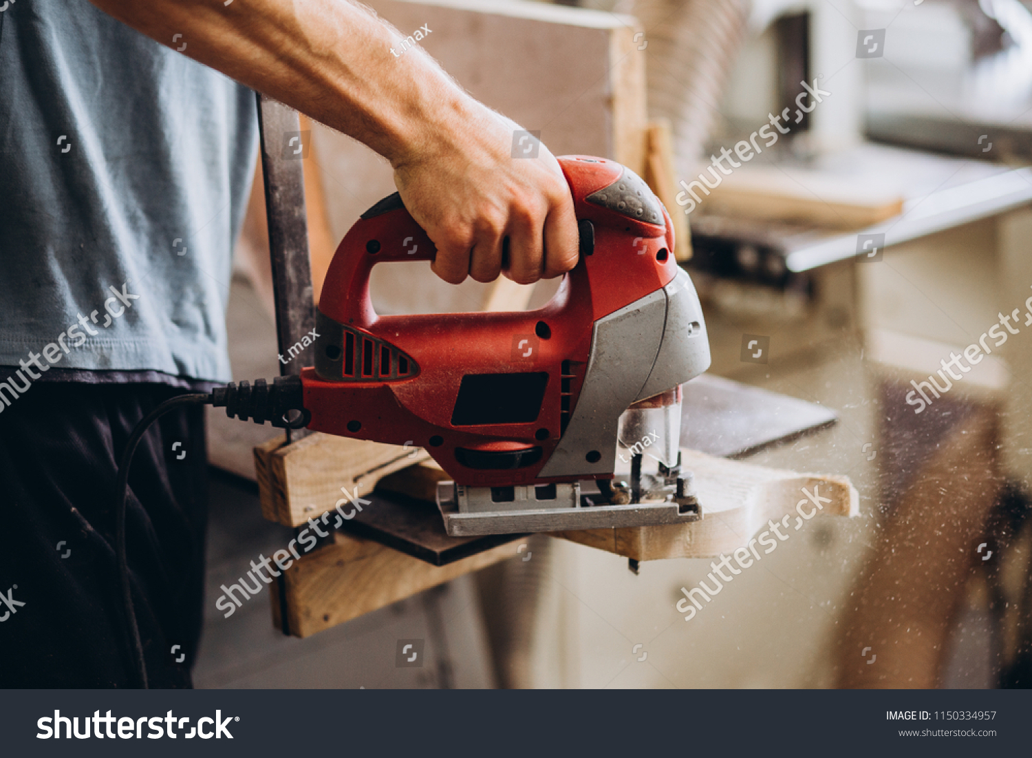 The carpenter, joiner, woodworker cutting the tree with an electric jig saw #1150334957