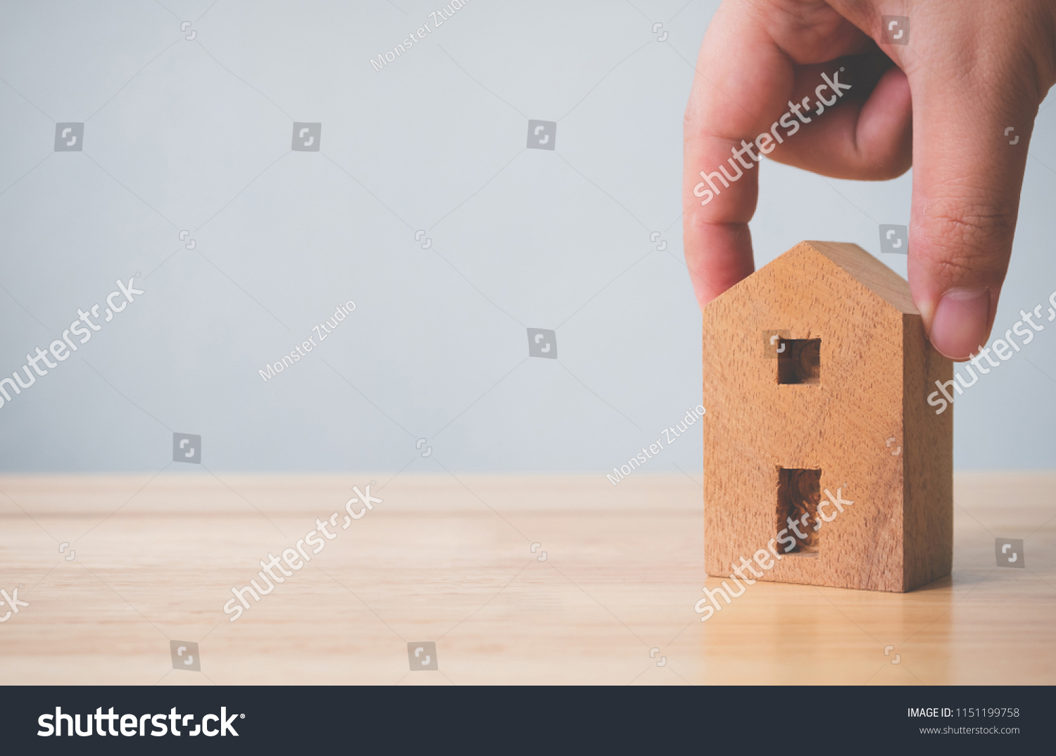 Property investment real estate and house mortgage financial concept. Hand holding wooden home on table #1151199758